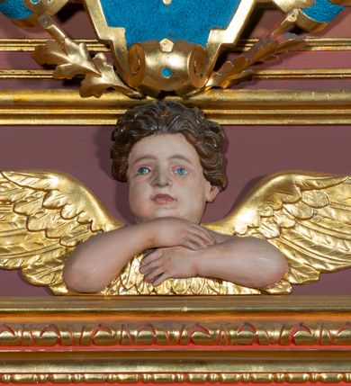 Zdjęcie nr 11: Ołtarz architektoniczny, jednoosiowy, jednokondygnacyjny, ze zwieńczeniem. Retabulum osadzone jest na wysokim, zdwojonym, zryzalitowanym uskokowo cokole. Ołtarz jest prostopadłościenny z drewnianą mensą. Pośrodku mensy znajduje się tabernakulum w formie prostopadłościennej szafki o lekko wypukłej przedniej ściance. Z przodu naroża ujmuje para półkolumienek, z tyłu półwałków. Prostokątne, zamknięte łukiem wklęsło-wypukłym drzwiczki zdobi polichromowane przedstawienie kielicha eucharystycznego na obłokach. Część środkową retabulum ujmuje para kolumn o żłobkowanych trzonach i korynckich kapitelach, ustawionych na tle zdwojonych pilastrów. Podpory dźwigają wyłamujące się ponad nimi belkowanie o silnie wysuniętym gzymsie. Zwieńczenie ma formę aediculi ujętej parą pilastrów i spływów wolutowych, zamkniętej trójkątnym przyczółkiem. Dodatkowo ujęta jest ona przerwanym, półkolistym przyczółkiem. Płycina antepedium jest w kształcie leżącego prostokąta z płaskorzeźbionym motywem złoconego, gorejącego serca, krzyża i kotwicy na tle srebrzonych obłoków ujętych promienistą glorią. Płyciny górnego cokołu (predelli) wypełnia stylizowana ornamentyka roślinna. Część środkową ujmuje para ażurowych uszaków z motywem kwiatu oraz wici akantu. U góry, pośrodku znajduje się uskrzydlona główka anielska. Powyżej, w partii belkowania, którego gzyms zdobi kostokowanie, umieszczony jest kartusz herbowy z monogramem maryjnym. Fryz zdobi stylizowana wić roślinna oraz para uskrzydlonych główek anielskich, natomiast zwieńczenie retabulum m.in. motywy roślinne, rozetki i kampanule. Szczyt tworzy podtrzymująca koronę para aniołów o sylwetkach od pasa w dół w formie liści akantu. Na przerwanym przyczółku znajduje się para przysiadających aniołów w sukniach w kolorze jasnofioletowym i pomarańczowym oraz złoconych płaszczach. Pole w części środkowej ma kształt stojącego prostokąta ujętego profilowaną, złoconą ramą. W środku znajduje się wizerunek Najświętszego Serca Jezusa. Pole w zwieńczeniu ma kształt stojącego owalu ujętego złoconą ramą w formie wieńca laurowego. Zawiera scenę Chrztu Jezusa w Jordanie. 
Struktura retabulum utrzymana jest w odcieniach brązu, partie detalu architektonicznego i ornamentyka są złocone. 
