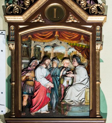 Zdjęcie nr 1: Czternaście płaskorzeźbionych stacji Drogi krzyżowej składa się z przedstawienia ujętego w taką samą architektoniczną, drewnianą ramę. Pole obrazowe uzyskał kształt stojącego prostokąta zamkniętego u góry łukiem odcinkowym. Flankują go smukłe półkolumienki wsparte na niskich bazach, ustawionych na prostokątnym, profilowanym cokole wspartym od dołu po bokach niewielkimi konsolami oraz udekorowanym podwieszonym na osi stylizowanym ornamentem roślinnym. Na cokole umieszczono podpis poszczególnej stacji. Kolumienki podtrzymują profilowane belkowanie w kształcie nadwieszonego trójkąta zwieńczonego krzyżem. Zewnętrze boki trójkąta zdobi ażurowy, złocony ornament roślinny. W polu trójkąta w medalionie wpisano kolejny numer stacji. Strukturę obramienia polichromowano na brązowo, natomiast kolumienki, wieńczące krzyże, ornamenty oraz profile zostały pozłocone. W polach obrazowych znalazły się wielopostaciowe, płaskorzeźbione kompozycje umieszczone najczęściej na tle pejzażu i architektury. Narracja każdego z obrazów skupia się na osobie Chrystusa, któremu towarzyszą inni ludzie, zgodnie z narracją kolejnej stacji. Przedstawione postacie wykonują gwałtowne i dynamiczne gesty. Na ich twarzach o jasnych karnacjach widoczne są różne emocje. Postacie ubrane są w obficie drapowane szaty o intensywnej i kontrastowej kolorystyce. Cykl przedstawia stacje z następującymi podpisami: I. Pan Jezus przez Piłata na śmierć skazany, II. Pan Jezus bierze krzyż na barki, III. Pan Jezus upada po raz pierwszy, IV. Pan Jezus spotyka się ze swoją Matką, V. Panu Jezusowi dopomaga Szymon Cyrenejczyk, VI. Panu Jezusowi ociera twarz św. Weronika, VII. Pan Jezus upada drugi raz, VIII. Pan Jezus pociesza płaczące niewiasty, IX. Pan Jezus upada po raz trzeci, X. Pan Jezus obnażony i żółcią napawany, XI. Pan Jezus do krzyża przybijany, XII. Pan Jezus umiera na krzyżu, XIII. Pan Jezus z krzyża zdjęty, XIV. Pan Jezus złożony w grobie. 