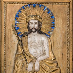 Zdjęcie nr 1: Obraz uzyskał kształt stojącego prostokąta ujętego złoconą, profilowaną ramą z dekoracją w typie wolich oczu. W centrum płaskorzeźbionej kompozycji ukazano frontalnie w dwóch trzecich Chrystusa ze skrzyżowanymi z przodu i związanymi złoconym sznurem rękami. W lewej dłoni Jezus trzyma trzcinę. Ma pociągłą twarz o jasnej karnacji okoloną krótką brodą i brązowymi włosami spływającymi na ramiona. Zbawiciel ma duży, prosty nos, wydatne usta i szeroko otwarte ciemne oczy o spojrzeniu skierowanym na widza. Na głowie ma złoconą koronę cierniową, spod której spływają krople krwi. Jego głowę otaczają ostre, złocone promienie na tle błękitnego nimbu. Krew widoczna jest także na odsłoniętym torsie oraz rękach. Chrystus ubrany jest w złocony płaszcz narzucony na ramiona odsłaniający jego nagi tors. Poniżej widać płaskorzeźbioną i złoconą girlandę różaną. 