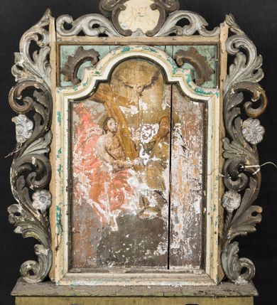 Zdjęcie nr 2: Feretron utworzono z prostopadłościennej podstawy w formie wydłużonego postumentu z otworami przeznaczonymi na drążki do noszenia oraz czworobocznego obramienia dekorowanego z trzech stron pierwotnie złoconą, ażurową wicią stylizowanego akantu z kwiatami. Na zwieńczeniu w owalu wyobrażona na awersie monogram maryjny a na rewersie chrystogram &quot;IHS&quot;. Dwustronne pole obrazowe uzyskało kształt stojącego prostokąta. Na rewersie w pole feretronu wpisano prostokątną, profilowaną ramą zakończoną u góry nadwieszonym łukiem odcinkowym z uskokiem, którą flankują dwa grzebienie rocaillowe. W polu ramy ukazano Trójcę Przenajświętszą. Frontalnie ujęty Bóg Ojciec został wyobrażony z prawej strony kompozycji jako siwobrody starzec o bujnych siwych włosach. W prawej ręce trzyma złote berło, lewą zaś odsuwa od siebie. Jego obie stopy opierają się na umieszczonym po środku globie ziemskim. Twarz Boga Ojca charakteryzuje jasna karnacja, szeroko otwarte oczy, wydatny nos i usta. Obok Boga Ojca z lewej strony siedzi Chrystus, który obie nogi wspiera na globie. Zbawiciel trzymający oburącz drewniany krzyż oparty o swoje lewe ramię został przedstawiony w trzech czwartych w prawo. Jest to dojrzały mężczyzna o pociągłej twarzy okolonej brązowymi, długimi włosami spływającymi na ramiona oraz krótką brodą. Ma jasną karnację, prosty nos i wydatne usta. Nagi tors okrywa w partii bioder rozwiany, bladoszkarłatny płaszcz odsłaniający prawą stopę. Na dłoniach i stopach widoczne są rany po gwoździach. Głowę Jezusa otacza świetlisty nimb. Powyżej obu postaci unosi się gołębica Ducha Świętego w promienistym otoku. Obraz na rewersie został ujęty profilowaną, prostokątną ramą. W centrum kompozycji na ochrowym tle na architektonicznym tronie wystawienia, utworzonym z odcinka wklęsłego belkowania wspartego na dwóch spływach wolutowych, przechodzących w dwa flankujące go cokoły ukazano wspartą na trzech uskrzydlonych główkach anielskich promienistą monstrancję z hostią. Monstrancja zwieńczona zamkniętą koroną została namalowana na jaśniejącym tle otoczonym obłokami z promieniami. W jej centrum na hostii umieszczono chrystogram &quot;IHS&quot;. Po bokach tronu na cokołach klęczą dwa nagie uskrzydlone aniołki.  