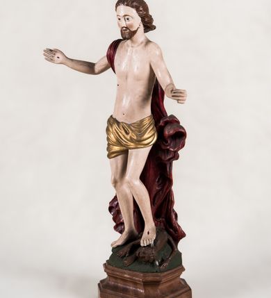 Zdjęcie nr 5: Pełnoplastyczna, całopostaciowa figura ukazuje Chrystusa Zmartwychwstałego stojącego na podłożu imitującym niewielki pagórek, osadzonym na profilowanej, prostopadłościennej podstawie o ściętych narożach. Zbawiciel na lekko ugiętych nogach ukazany został frontalnie. Obie ręce ma uniesione i odsunięte od tułowia. W lewej trzyma chorągiew na drzewcu z czerwonej tkaniny obszytej srebrną frędzlą i dekorowanej cekinami. Z kolei prawa jest uniesiona na wysokości klatki piersiowej. Jego sylwetka została opracowana sumarycznie z próbą uchwycenia muskulatury oraz zaznaczeniem partii żeber. Biodra Zbawiciela okrywa przewiązane, pozłocone perizonium. Chrystus ma owalną twarz o jasnej karnacji z charakterystycznie szeroko otwartymi oczami, wydatny nos i usta. Jego głowę otaczają krótkie brązowe włosy zaczesane do tyłu i zarost. Przez prawe ramię ma przerzucony, mocno sfałdowany, ciemnoczerwony płaszcz osłaniający tył sylwetki. Na dłoniach, stopach i w prawym boku widoczne są rany. Jezus lewą nogą depcze leżącego na podłożu szatana o groteskowej, brązowej sylwetce z ogonem, srebrzonymi, prostymi rogami, czerwonymi oczami oraz łapami zakończonymi czerwonymi pazurami. Na odwrocie widnieje napis: Odnowiono / 1960 St(Janisław) Rupik / Dzieło x(iędza) Roberta / Pioteckiego / 1615.
