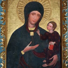 Zdjęcie nr 1: Obraz w kształcie stojącego prostokąta, z przedstawieniem Matki Boskiej z Dzieciątkiem w typie Hodegetrii Krakowskiej. Maria przedstawiona w półpostaci, z głową przechyloną na lewo. Lewą ręką obejmuje Dzieciątko, dłonią prawej ręki wskazuje na Syna. Twarz owalna o ciemnej karnacji z policzkami podkreślonymi różem, o regularnych łukach brwiowych, głęboko osadzonych oczach, długim wąskim nosie, drobnych czerwonych ustach. Dłonie wysmukłe, o długich palcach. Ubrana ciemnoniebieską suknię z wąskimi rękawami, ozdobioną pod szyją i końcach rękawów złotą bordiurą. Cała postać okryta maforium w takim samym kolorze co suknia, z czerwoną podszewką, ozdobionym cienką złotą lamówką i spiętym na piersiach rombową złotą broszą. Spod maforionu widoczny czepiec na głowie. Dzieciątko, ujęte w trzech czwartych, zwrócone w prawo, w kierunku Matki, Siedzi na jej lewym przedramieniu. Głowa kulista, z ciemnymi kędzierzawymi włosami ułożonymi w loki podkreślone złotymi kreskami ; twarz o ciemnej karnacji z zaróżowionymi policzkami. Prawą dłonią błogosławi, lewą podtrzymuje kodeks w czerwonej oprawie oparty na lewym kolanie. Ubrane w długą i szeroką ciemnoczerwoną sukienkę, ozdobioną drobnym wzorem patronowym malowanym złotem w proszku. Spod sukienki widać bose stopy.  Wokół głowy Marii nimb promienisty, wokół głowy Dzieciątka nimb krzyżowy. Tło (wtórne) złocone, w narożach z motywami uproszczonej wici roślinnej.