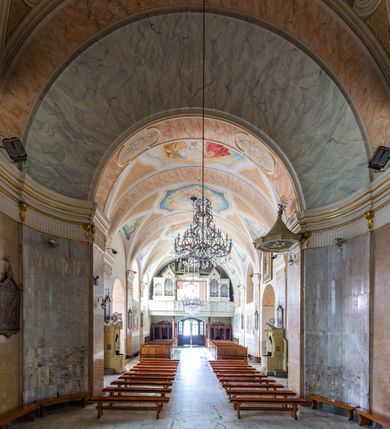 Zdjęcie nr 10: Po kilkukrotnych przekształceniach kościół składa się z prostokątnej, czteroprzęsłowej nawy głównej, dwóch, dwuprzęsłowych naw bocznych, przerobionych z dawnych kaplic i jednoprzęsłowego prezbiterium zamkniętego od wschodu apsydą. Na przedłużeniu apsydy otoczonej półkolistym aneksem wzniesiono czworoboczną, piętrową zakrystią. Od zachodu do nawy przylega wysunięta do przodu czworoboczna wieża o ściętych narożach z urządzoną w przyziemiu kruchtą. Wieża uzyskała trzy kondygnacje wyznaczone za pomocą profilowanych gzymsów. Środkowe piętro wieży połączono z bocznymi częściami fasady za pomocą wolut. Na dwóch pierwszych kondygnacjach ścięte naroża artykułowano za pomocą pilastrów o prostych głowicach. Pilastry drugiej kondygnacji ozdobiono krótkimi zwisami kampanul. Kondygnacja trzecia także została wzniesiona na rzucie czworoboku ale o wklęsłych narożach. Jej ściany flankują pary pilastrów o korynckich głowicach podtrzymujące imposty wspierające półkoliście wyłamane na osi belkowanie wspierające baniasty hełm z latarnią zwieńczony krzyżem z koroną. Pomiędzy impostami pod wyłamanym belkowaniem umieszczono tarcze zegarowe. Na trzeciej kondygnacji ponad belkowaniem od zachodu nadwieszono czworoboczny balkon z tralkową balustradą. Sześcioboczną sygnaturkę z latarnią zwieńczoną stożkowym hełmem z ustawioną na szczycie figurką Matki Boskiej Niepokalanie Poczętej zawieszono na siodłowym dachu kościoła w części wschodniej nawy głównej. Elewacje boczne kościoła rozczłonkowano za pomocą podziałów ramowych lub lizenowych. Wnętrze świątyni nakryto sklepieniem kolebkowym wspartym na gurtach, przechodzących na przyścienne pilastry podtrzymujące odcinki przerwanego belkowania. W ostanim zachodnim przęśle urządzono chór muzyczny wsparty na dwóch filarach z wypukłym na osi parapetem, artykułowanym za pomocą pilastrów i par arkadek. W prezbiterium ustawiono ołtarz główny oraz ambonę, a w nawach ołtarze boczne. 