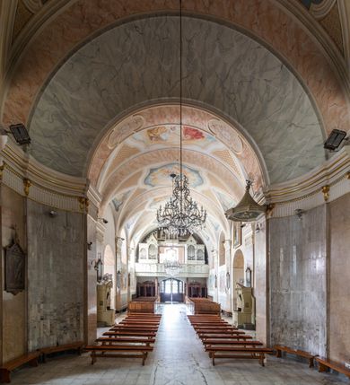 Zdjęcie nr 12: Po kilkukrotnych przekształceniach kościół składa się z prostokątnej, czteroprzęsłowej nawy głównej, dwóch, dwuprzęsłowych naw bocznych, przerobionych z dawnych kaplic i jednoprzęsłowego prezbiterium zamkniętego od wschodu apsydą. Na przedłużeniu apsydy otoczonej półkolistym aneksem wzniesiono czworoboczną, piętrową zakrystią. Od zachodu do nawy przylega wysunięta do przodu czworoboczna wieża o ściętych narożach z urządzoną w przyziemiu kruchtą. Wieża uzyskała trzy kondygnacje wyznaczone za pomocą profilowanych gzymsów. Środkowe piętro wieży połączono z bocznymi częściami fasady za pomocą wolut. Na dwóch pierwszych kondygnacjach ścięte naroża artykułowano za pomocą pilastrów o prostych głowicach. Pilastry drugiej kondygnacji ozdobiono krótkimi zwisami kampanul. Kondygnacja trzecia także została wzniesiona na rzucie czworoboku ale o wklęsłych narożach. Jej ściany flankują pary pilastrów o korynckich głowicach podtrzymujące imposty wspierające półkoliście wyłamane na osi belkowanie wspierające baniasty hełm z latarnią zwieńczony krzyżem z koroną. Pomiędzy impostami pod wyłamanym belkowaniem umieszczono tarcze zegarowe. Na trzeciej kondygnacji ponad belkowaniem od zachodu nadwieszono czworoboczny balkon z tralkową balustradą. Sześcioboczną sygnaturkę z latarnią zwieńczoną stożkowym hełmem z ustawioną na szczycie figurką Matki Boskiej Niepokalanie Poczętej zawieszono na siodłowym dachu kościoła w części wschodniej nawy głównej. Elewacje boczne kościoła rozczłonkowano za pomocą podziałów ramowych lub lizenowych. Wnętrze świątyni nakryto sklepieniem kolebkowym wspartym na gurtach, przechodzących na przyścienne pilastry podtrzymujące odcinki przerwanego belkowania. W ostanim zachodnim przęśle urządzono chór muzyczny wsparty na dwóch filarach z wypukłym na osi parapetem, artykułowanym za pomocą pilastrów i par arkadek. W prezbiterium ustawiono ołtarz główny oraz ambonę, a w nawach ołtarze boczne. 