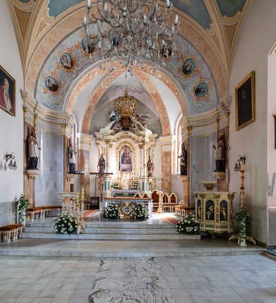 Zdjęcie nr 4: Po kilkukrotnych przekształceniach kościół składa się z prostokątnej, czteroprzęsłowej nawy głównej, dwóch, dwuprzęsłowych naw bocznych, przerobionych z dawnych kaplic i jednoprzęsłowego prezbiterium zamkniętego od wschodu apsydą. Na przedłużeniu apsydy otoczonej półkolistym aneksem wzniesiono czworoboczną, piętrową zakrystią. Od zachodu do nawy przylega wysunięta do przodu czworoboczna wieża o ściętych narożach z urządzoną w przyziemiu kruchtą. Wieża uzyskała trzy kondygnacje wyznaczone za pomocą profilowanych gzymsów. Środkowe piętro wieży połączono z bocznymi częściami fasady za pomocą wolut. Na dwóch pierwszych kondygnacjach ścięte naroża artykułowano za pomocą pilastrów o prostych głowicach. Pilastry drugiej kondygnacji ozdobiono krótkimi zwisami kampanul. Kondygnacja trzecia także została wzniesiona na rzucie czworoboku ale o wklęsłych narożach. Jej ściany flankują pary pilastrów o korynckich głowicach podtrzymujące imposty wspierające półkoliście wyłamane na osi belkowanie wspierające baniasty hełm z latarnią zwieńczony krzyżem z koroną. Pomiędzy impostami pod wyłamanym belkowaniem umieszczono tarcze zegarowe. Na trzeciej kondygnacji ponad belkowaniem od zachodu nadwieszono czworoboczny balkon z tralkową balustradą. Sześcioboczną sygnaturkę z latarnią zwieńczoną stożkowym hełmem z ustawioną na szczycie figurką Matki Boskiej Niepokalanie Poczętej zawieszono na siodłowym dachu kościoła w części wschodniej nawy głównej. Elewacje boczne kościoła rozczłonkowano za pomocą podziałów ramowych lub lizenowych. Wnętrze świątyni nakryto sklepieniem kolebkowym wspartym na gurtach, przechodzących na przyścienne pilastry podtrzymujące odcinki przerwanego belkowania. W ostanim zachodnim przęśle urządzono chór muzyczny wsparty na dwóch filarach z wypukłym na osi parapetem, artykułowanym za pomocą pilastrów i par arkadek. W prezbiterium ustawiono ołtarz główny oraz ambonę, a w nawach ołtarze boczne. 