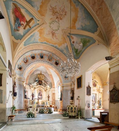 Zdjęcie nr 7: Po kilkukrotnych przekształceniach kościół składa się z prostokątnej, czteroprzęsłowej nawy głównej, dwóch, dwuprzęsłowych naw bocznych, przerobionych z dawnych kaplic i jednoprzęsłowego prezbiterium zamkniętego od wschodu apsydą. Na przedłużeniu apsydy otoczonej półkolistym aneksem wzniesiono czworoboczną, piętrową zakrystią. Od zachodu do nawy przylega wysunięta do przodu czworoboczna wieża o ściętych narożach z urządzoną w przyziemiu kruchtą. Wieża uzyskała trzy kondygnacje wyznaczone za pomocą profilowanych gzymsów. Środkowe piętro wieży połączono z bocznymi częściami fasady za pomocą wolut. Na dwóch pierwszych kondygnacjach ścięte naroża artykułowano za pomocą pilastrów o prostych głowicach. Pilastry drugiej kondygnacji ozdobiono krótkimi zwisami kampanul. Kondygnacja trzecia także została wzniesiona na rzucie czworoboku ale o wklęsłych narożach. Jej ściany flankują pary pilastrów o korynckich głowicach podtrzymujące imposty wspierające półkoliście wyłamane na osi belkowanie wspierające baniasty hełm z latarnią zwieńczony krzyżem z koroną. Pomiędzy impostami pod wyłamanym belkowaniem umieszczono tarcze zegarowe. Na trzeciej kondygnacji ponad belkowaniem od zachodu nadwieszono czworoboczny balkon z tralkową balustradą. Sześcioboczną sygnaturkę z latarnią zwieńczoną stożkowym hełmem z ustawioną na szczycie figurką Matki Boskiej Niepokalanie Poczętej zawieszono na siodłowym dachu kościoła w części wschodniej nawy głównej. Elewacje boczne kościoła rozczłonkowano za pomocą podziałów ramowych lub lizenowych. Wnętrze świątyni nakryto sklepieniem kolebkowym wspartym na gurtach, przechodzących na przyścienne pilastry podtrzymujące odcinki przerwanego belkowania. W ostanim zachodnim przęśle urządzono chór muzyczny wsparty na dwóch filarach z wypukłym na osi parapetem, artykułowanym za pomocą pilastrów i par arkadek. W prezbiterium ustawiono ołtarz główny oraz ambonę, a w nawach ołtarze boczne. 