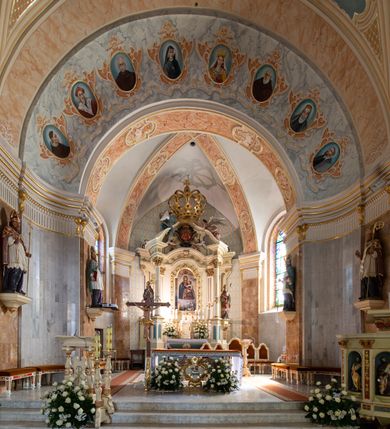 Zdjęcie nr 5: Po kilkukrotnych przekształceniach kościół składa się z prostokątnej, czteroprzęsłowej nawy głównej, dwóch, dwuprzęsłowych naw bocznych, przerobionych z dawnych kaplic i jednoprzęsłowego prezbiterium zamkniętego od wschodu apsydą. Na przedłużeniu apsydy otoczonej półkolistym aneksem wzniesiono czworoboczną, piętrową zakrystią. Od zachodu do nawy przylega wysunięta do przodu czworoboczna wieża o ściętych narożach z urządzoną w przyziemiu kruchtą. Wieża uzyskała trzy kondygnacje wyznaczone za pomocą profilowanych gzymsów. Środkowe piętro wieży połączono z bocznymi częściami fasady za pomocą wolut. Na dwóch pierwszych kondygnacjach ścięte naroża artykułowano za pomocą pilastrów o prostych głowicach. Pilastry drugiej kondygnacji ozdobiono krótkimi zwisami kampanul. Kondygnacja trzecia także została wzniesiona na rzucie czworoboku ale o wklęsłych narożach. Jej ściany flankują pary pilastrów o korynckich głowicach podtrzymujące imposty wspierające półkoliście wyłamane na osi belkowanie wspierające baniasty hełm z latarnią zwieńczony krzyżem z koroną. Pomiędzy impostami pod wyłamanym belkowaniem umieszczono tarcze zegarowe. Na trzeciej kondygnacji ponad belkowaniem od zachodu nadwieszono czworoboczny balkon z tralkową balustradą. Sześcioboczną sygnaturkę z latarnią zwieńczoną stożkowym hełmem z ustawioną na szczycie figurką Matki Boskiej Niepokalanie Poczętej zawieszono na siodłowym dachu kościoła w części wschodniej nawy głównej. Elewacje boczne kościoła rozczłonkowano za pomocą podziałów ramowych lub lizenowych. Wnętrze świątyni nakryto sklepieniem kolebkowym wspartym na gurtach, przechodzących na przyścienne pilastry podtrzymujące odcinki przerwanego belkowania. W ostanim zachodnim przęśle urządzono chór muzyczny wsparty na dwóch filarach z wypukłym na osi parapetem, artykułowanym za pomocą pilastrów i par arkadek. W prezbiterium ustawiono ołtarz główny oraz ambonę, a w nawach ołtarze boczne. 