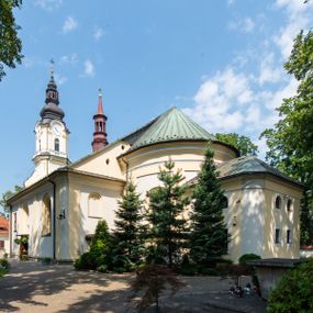 Zdjęcie nr 1: Po kilkukrotnych przekształceniach kościół składa się z prostokątnej, czteroprzęsłowej nawy głównej, dwóch, dwuprzęsłowych naw bocznych, przerobionych z dawnych kaplic i jednoprzęsłowego prezbiterium zamkniętego od wschodu apsydą. Na przedłużeniu apsydy otoczonej półkolistym aneksem wzniesiono czworoboczną, piętrową zakrystią. Od zachodu do nawy przylega wysunięta do przodu czworoboczna wieża o ściętych narożach z urządzoną w przyziemiu kruchtą. Wieża uzyskała trzy kondygnacje wyznaczone za pomocą profilowanych gzymsów. Środkowe piętro wieży połączono z bocznymi częściami fasady za pomocą wolut. Na dwóch pierwszych kondygnacjach ścięte naroża artykułowano za pomocą pilastrów o prostych głowicach. Pilastry drugiej kondygnacji ozdobiono krótkimi zwisami kampanul. Kondygnacja trzecia także została wzniesiona na rzucie czworoboku ale o wklęsłych narożach. Jej ściany flankują pary pilastrów o korynckich głowicach podtrzymujące imposty wspierające półkoliście wyłamane na osi belkowanie wspierające baniasty hełm z latarnią zwieńczony krzyżem z koroną. Pomiędzy impostami pod wyłamanym belkowaniem umieszczono tarcze zegarowe. Na trzeciej kondygnacji ponad belkowaniem od zachodu nadwieszono czworoboczny balkon z tralkową balustradą. Sześcioboczną sygnaturkę z latarnią zwieńczoną stożkowym hełmem z ustawioną na szczycie figurką Matki Boskiej Niepokalanie Poczętej zawieszono na siodłowym dachu kościoła w części wschodniej nawy głównej. Elewacje boczne kościoła rozczłonkowano za pomocą podziałów ramowych lub lizenowych. Wnętrze świątyni nakryto sklepieniem kolebkowym wspartym na gurtach, przechodzących na przyścienne pilastry podtrzymujące odcinki przerwanego belkowania. W ostanim zachodnim przęśle urządzono chór muzyczny wsparty na dwóch filarach z wypukłym na osi parapetem, artykułowanym za pomocą pilastrów i par arkadek. W prezbiterium ustawiono ołtarz główny oraz ambonę, a w nawach ołtarze boczne. 