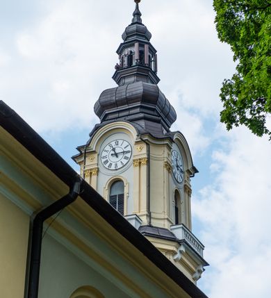 Zdjęcie nr 29: Po kilkukrotnych przekształceniach kościół składa się z prostokątnej, czteroprzęsłowej nawy głównej, dwóch, dwuprzęsłowych naw bocznych, przerobionych z dawnych kaplic i jednoprzęsłowego prezbiterium zamkniętego od wschodu apsydą. Na przedłużeniu apsydy otoczonej półkolistym aneksem wzniesiono czworoboczną, piętrową zakrystią. Od zachodu do nawy przylega wysunięta do przodu czworoboczna wieża o ściętych narożach z urządzoną w przyziemiu kruchtą. Wieża uzyskała trzy kondygnacje wyznaczone za pomocą profilowanych gzymsów. Środkowe piętro wieży połączono z bocznymi częściami fasady za pomocą wolut. Na dwóch pierwszych kondygnacjach ścięte naroża artykułowano za pomocą pilastrów o prostych głowicach. Pilastry drugiej kondygnacji ozdobiono krótkimi zwisami kampanul. Kondygnacja trzecia także została wzniesiona na rzucie czworoboku ale o wklęsłych narożach. Jej ściany flankują pary pilastrów o korynckich głowicach podtrzymujące imposty wspierające półkoliście wyłamane na osi belkowanie wspierające baniasty hełm z latarnią zwieńczony krzyżem z koroną. Pomiędzy impostami pod wyłamanym belkowaniem umieszczono tarcze zegarowe. Na trzeciej kondygnacji ponad belkowaniem od zachodu nadwieszono czworoboczny balkon z tralkową balustradą. Sześcioboczną sygnaturkę z latarnią zwieńczoną stożkowym hełmem z ustawioną na szczycie figurką Matki Boskiej Niepokalanie Poczętej zawieszono na siodłowym dachu kościoła w części wschodniej nawy głównej. Elewacje boczne kościoła rozczłonkowano za pomocą podziałów ramowych lub lizenowych. Wnętrze świątyni nakryto sklepieniem kolebkowym wspartym na gurtach, przechodzących na przyścienne pilastry podtrzymujące odcinki przerwanego belkowania. W ostanim zachodnim przęśle urządzono chór muzyczny wsparty na dwóch filarach z wypukłym na osi parapetem, artykułowanym za pomocą pilastrów i par arkadek. W prezbiterium ustawiono ołtarz główny oraz ambonę, a w nawach ołtarze boczne. 