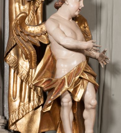 Zdjęcie nr 21: Nastawa niearchitektoniczna w formie paludamentu. Mensa kamienna, oparta na dwóch kamiennych pilastrach o kanelowanych trzonach, ustawionych na cokolikach. Na mensie  tabernakulum w formie drewnianej skrzynki na czterech nóżkach, zakończone gzymsem, o drzwiczkach w kształcie stojącego prostokąta o ściętych górnych narożach, ujęte profilowaną ramą z przedstawieniem kielicha z hostią w glorii. Na nim tron wystawienia na relikwiarz. Tabernakulum flankują dwie figury aniołów ustawione na cokołach. 
Paludament podwiązany po bokach sznurem z chwostami, podtrzymywany przez putta, lamowany frędzlą, zwieńczony baldachimem utworzonym z fragmentu wklęsło-wypukłego gzymsu z lambrekinem. W polu wnęka w kształcie stojącego prostokąta ujęta profilowaną ramą i rocaille'm, z obrazem św. Karola Boromeusza. Nad obrazem rzeźbione obłoki i dwie uskrzydlone główki anielskie, po bokach nadlatujące dwa putta. Paludament polichromowany wewnątrz w kolorze szaro-brązowym, zewnątrz złocony.