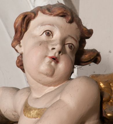 Zdjęcie nr 29: Nastawa niearchitektoniczna w formie paludamentu. Mensa kamienna, oparta na dwóch kamiennych pilastrach o kanelowanych trzonach, ustawionych na cokolikach. Na mensie  tabernakulum w formie drewnianej skrzynki na czterech nóżkach, zakończone gzymsem, o drzwiczkach w kształcie stojącego prostokąta o ściętych górnych narożach, ujęte profilowaną ramą z przedstawieniem kielicha z hostią w glorii. Na nim tron wystawienia na relikwiarz. Tabernakulum flankują dwie figury aniołów ustawione na cokołach. 
Paludament podwiązany po bokach sznurem z chwostami, podtrzymywany przez putta, lamowany frędzlą, zwieńczony baldachimem utworzonym z fragmentu wklęsło-wypukłego gzymsu z lambrekinem. W polu wnęka w kształcie stojącego prostokąta ujęta profilowaną ramą i rocaille'm, z obrazem św. Karola Boromeusza. Nad obrazem rzeźbione obłoki i dwie uskrzydlone główki anielskie, po bokach nadlatujące dwa putta. Paludament polichromowany wewnątrz w kolorze szaro-brązowym, zewnątrz złocony.