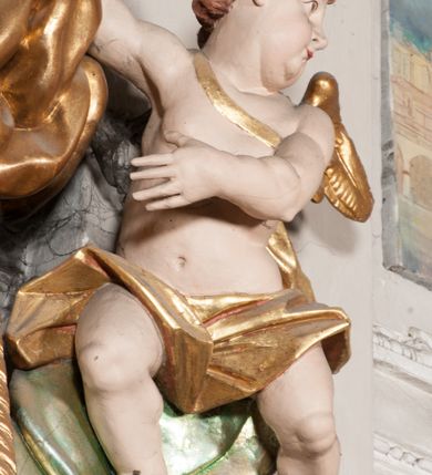 Zdjęcie nr 32: Nastawa niearchitektoniczna w formie paludamentu. Mensa kamienna, oparta na dwóch kamiennych pilastrach o kanelowanych trzonach, ustawionych na cokolikach. Na mensie  tabernakulum w formie drewnianej skrzynki na czterech nóżkach, zakończone gzymsem, o drzwiczkach w kształcie stojącego prostokąta o ściętych górnych narożach, ujęte profilowaną ramą z przedstawieniem kielicha z hostią w glorii. Na nim tron wystawienia na relikwiarz. Tabernakulum flankują dwie figury aniołów ustawione na cokołach. 
Paludament podwiązany po bokach sznurem z chwostami, podtrzymywany przez putta, lamowany frędzlą, zwieńczony baldachimem utworzonym z fragmentu wklęsło-wypukłego gzymsu z lambrekinem. W polu wnęka w kształcie stojącego prostokąta ujęta profilowaną ramą i rocaille'm, z obrazem św. Karola Boromeusza. Nad obrazem rzeźbione obłoki i dwie uskrzydlone główki anielskie, po bokach nadlatujące dwa putta. Paludament polichromowany wewnątrz w kolorze szaro-brązowym, zewnątrz złocony.