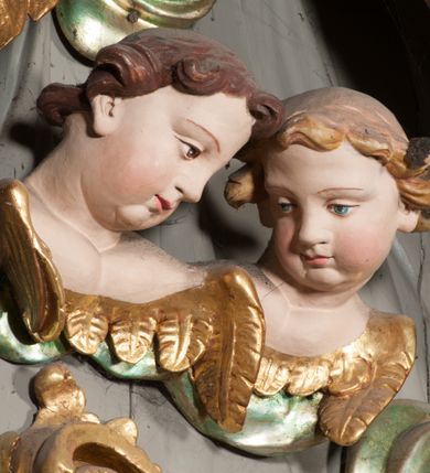 Zdjęcie nr 39: Nastawa niearchitektoniczna w formie paludamentu. Mensa kamienna, oparta na dwóch kamiennych pilastrach o kanelowanych trzonach, ustawionych na cokolikach. Na mensie  tabernakulum w formie drewnianej skrzynki na czterech nóżkach, zakończone gzymsem, o drzwiczkach w kształcie stojącego prostokąta o ściętych górnych narożach, ujęte profilowaną ramą z przedstawieniem kielicha z hostią w glorii. Na nim tron wystawienia na relikwiarz. Tabernakulum flankują dwie figury aniołów ustawione na cokołach. 
Paludament podwiązany po bokach sznurem z chwostami, podtrzymywany przez putta, lamowany frędzlą, zwieńczony baldachimem utworzonym z fragmentu wklęsło-wypukłego gzymsu z lambrekinem. W polu wnęka w kształcie stojącego prostokąta ujęta profilowaną ramą i rocaille&#039;m, z obrazem św. Karola Boromeusza. Nad obrazem rzeźbione obłoki i dwie uskrzydlone główki anielskie, po bokach nadlatujące dwa putta. Paludament polichromowany wewnątrz w kolorze szaro-brązowym, zewnątrz złocony.