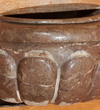 Zdjęcie nr 1: Kropielnica na planie koła, do połowy wmontowana w ścianę. Czara z wywiniętym brzegiem, zdobiona puklowaniem.