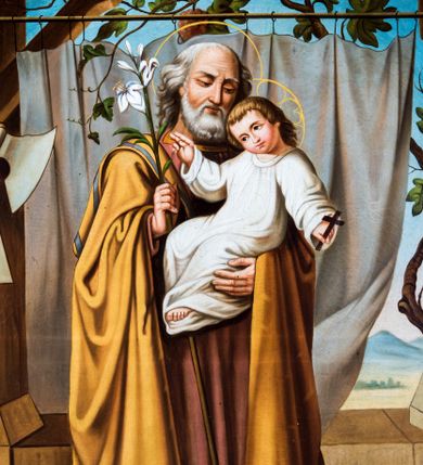 Zdjęcie nr 1: Obraz uzyskał formę stojącego prostokąta z całopostaciowym przedstawieniem św. Józefa z Dzieciątkiem. Józef zwrócony jest nieznacznie w trzech czwartych w lewo, z pochyloną głową. Święty lewą ręką podtrzymuje Dzieciątko, w prawej natomiast trzyma laskę zakończoną gałązką lilii. Twarz ma owalną, o starczych rysach, wysokim czole i migdałowatych oczach skierowanych w dół, długim nosie i pełnych ustach, okoloną siwą brodą oraz siwymi włosami sięgającymi ramion. Ubrany jest w długą ciemnoróżową tunikę oraz obficie drapowany, ciemnożółty płaszcz z zielonym pasem wzdłuż krawędzi zarzucony na ramiona. Wokół jego głowy widoczna jest złota aureola. Dzieciątko zwrócone zostało w trzech czwartych w prawo. Jezus z pochyloną głową i skrzyżowanymi stopami, prawą rękę unosi w geście błogosławieństwa, a w opuszczonej lewej dłoni trzyma krzyżyk. Zbawiciel ma okragłą twarz o dużych oczach, małym nosie i ustach, otoczoną jasnymi, krótkimi włosami. Jego głowę okala stylizowany nimb krzyżowy. Ubrany jest w białą obfitą tunikę. Postacie zostały ukazane w bliżej nieokreślonym wnętrzu otwierającym się na pejzaż zasadniczo przesłonięty kotarą zawieszoną na drążku, po którym pnie się winna latorośl. Po lewej stronie obrazu widoczne są zawieszone na filarze narzędzia ciesielskie (siekiera, kątownica, cyrkiel), a w prawym dolnym rogu wazon z różami.