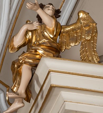 Zdjęcie nr 10: Dwukondygnacyjny, jednoosiowy ołtarz ze zwieńczeniem uzyskał strukturę architektoniczną. Stipes ołtarzowy wykonano w formie granitowego prostopadłościanu z mensą. Na mensie na osi ołtarza ustawiono tabernakulum z tronem wystawienia. Tabernakulum otrzymało kształt drewnianej skrzynki obitej blachą z drzwiczkami w formie stojącego prostokąta, z sześcioma kwaterami przedstawiającymi sceny z Pisma Świętego. Całość zamknięto silnie wysuniętym gzymsem wypukłym od frontu. Tron wystawienia utworzono w formie baldachimu ozdobionego lambrekinem z chwostami. Ujmują go spływy wolutowe z podwieszoną tkaniną, dekorowane liśćmi akantu. W przestrzeni zaplecka tronu umieszczono w promienistej glorii medalion z chrystogramem "IHS". Nastawa została ustawiona na wysokim cokole, zwieńczonym profilowanym gzymsem z wyodrębnionymi dwoma wspornikami skierowanymi do wewnątrz. Retabulum ujmuje  zwrócona na zewnątrz opilastrowana para filarów, przed którymi stoi para kolumn o kapitelach kompozytowych dźwigających pełne belkowanie wyłamane na ich osi. W polu centralnym znajduje się nisza w kształcie stojącego prostokąta zwieńczonego przerwanym prostokątnie łukiem półkolistym, nadwieszonym. Niszę obramienia profilowana rama. W jej wnętrzu znajduje się obraz Wniebowzięcia Najświętsze Marii Panny w drewnianych sukienkach wotywnych. Druga kondygnacja ujęta została dwiema parami zwróconych na zewnątrz pilastrów o trzonach przechodzących w spływy wolutowe. Pilastry dźwigają gzyms wyłamany na ich osi, który w części centralnej przyjmuje kształt spłaszczonego łuku. W polu umieszczono obraz z przedstawieniem Michała Archanioła w formie stojącego prostokąta o wklęsłych, dłuższych krawędziach oraz krótszych o kształcie łuku półkolistego nadwieszonego. Nastawa zakończona została okiem Opatrzności Bożej w glorii promienistej. Na cokole przed podporami ustawiono cztery figury adorujących aniołów. Ramę w polu środkowym udekorowano ornamentem roślinnym. W górnych przyłuczach umieszczono figury puttów na obłokach. Fryz został ozdobiony kwiatowymi girlandami. Centralnie na osi na gzymsie zawieszono kartusz z monogramem Marii w polu. Na zewnętrznych krawędziach belkowania pierwszej kondygnacji siedzą dwie figury aniołów, a na spływach wolutowych cztery putta. W trzonach pilastrów drugiej kondygnacji widoczne są zwisy z ornamentem kwiatowym podwieszonym na wstążce. W polu centralnym na dole umieszczono dwa wieńce, a u góry dwie uskrzydlone główki anielskie. Na belkowaniu znajdują się dwa putta na obłokach. Struktura nastawy została polichromowana w kolorze kości słoniowej, natomiast kolumny, pilastry, profile i ornamentyka zostały wyzłocone, a obłoki posrebrzone.