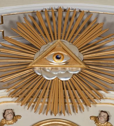 Zdjęcie nr 13: Dwukondygnacyjny, jednoosiowy ołtarz ze zwieńczeniem uzyskał strukturę architektoniczną. Stipes ołtarzowy wykonano w formie granitowego prostopadłościanu z mensą. Na mensie na osi ołtarza ustawiono tabernakulum z tronem wystawienia. Tabernakulum otrzymało kształt drewnianej skrzynki obitej blachą z drzwiczkami w formie stojącego prostokąta, z sześcioma kwaterami przedstawiającymi sceny z Pisma Świętego. Całość zamknięto silnie wysuniętym gzymsem wypukłym od frontu. Tron wystawienia utworzono w formie baldachimu ozdobionego lambrekinem z chwostami. Ujmują go spływy wolutowe z podwieszoną tkaniną, dekorowane liśćmi akantu. W przestrzeni zaplecka tronu umieszczono w promienistej glorii medalion z chrystogramem "IHS". Nastawa została ustawiona na wysokim cokole, zwieńczonym profilowanym gzymsem z wyodrębnionymi dwoma wspornikami skierowanymi do wewnątrz. Retabulum ujmuje  zwrócona na zewnątrz opilastrowana para filarów, przed którymi stoi para kolumn o kapitelach kompozytowych dźwigających pełne belkowanie wyłamane na ich osi. W polu centralnym znajduje się nisza w kształcie stojącego prostokąta zwieńczonego przerwanym prostokątnie łukiem półkolistym, nadwieszonym. Niszę obramienia profilowana rama. W jej wnętrzu znajduje się obraz Wniebowzięcia Najświętsze Marii Panny w drewnianych sukienkach wotywnych. Druga kondygnacja ujęta została dwiema parami zwróconych na zewnątrz pilastrów o trzonach przechodzących w spływy wolutowe. Pilastry dźwigają gzyms wyłamany na ich osi, który w części centralnej przyjmuje kształt spłaszczonego łuku. W polu umieszczono obraz z przedstawieniem Michała Archanioła w formie stojącego prostokąta o wklęsłych, dłuższych krawędziach oraz krótszych o kształcie łuku półkolistego nadwieszonego. Nastawa zakończona została okiem Opatrzności Bożej w glorii promienistej. Na cokole przed podporami ustawiono cztery figury adorujących aniołów. Ramę w polu środkowym udekorowano ornamentem roślinnym. W górnych przyłuczach umieszczono figury puttów na obłokach. Fryz został ozdobiony kwiatowymi girlandami. Centralnie na osi na gzymsie zawieszono kartusz z monogramem Marii w polu. Na zewnętrznych krawędziach belkowania pierwszej kondygnacji siedzą dwie figury aniołów, a na spływach wolutowych cztery putta. W trzonach pilastrów drugiej kondygnacji widoczne są zwisy z ornamentem kwiatowym podwieszonym na wstążce. W polu centralnym na dole umieszczono dwa wieńce, a u góry dwie uskrzydlone główki anielskie. Na belkowaniu znajdują się dwa putta na obłokach. Struktura nastawy została polichromowana w kolorze kości słoniowej, natomiast kolumny, pilastry, profile i ornamentyka zostały wyzłocone, a obłoki posrebrzone.