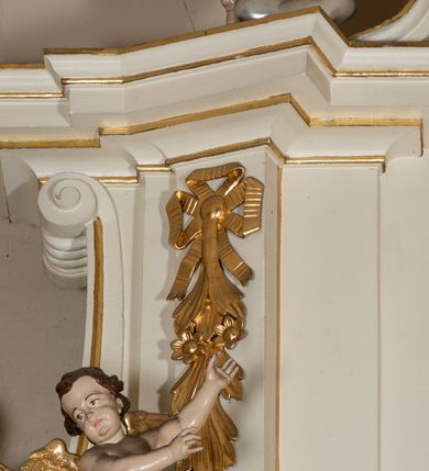 Zdjęcie nr 15: Dwukondygnacyjny, jednoosiowy ołtarz ze zwieńczeniem uzyskał strukturę architektoniczną. Stipes ołtarzowy wykonano w formie granitowego prostopadłościanu z mensą. Na mensie na osi ołtarza ustawiono tabernakulum z tronem wystawienia. Tabernakulum otrzymało kształt drewnianej skrzynki obitej blachą z drzwiczkami w formie stojącego prostokąta, z sześcioma kwaterami przedstawiającymi sceny z Pisma Świętego. Całość zamknięto silnie wysuniętym gzymsem wypukłym od frontu. Tron wystawienia utworzono w formie baldachimu ozdobionego lambrekinem z chwostami. Ujmują go spływy wolutowe z podwieszoną tkaniną, dekorowane liśćmi akantu. W przestrzeni zaplecka tronu umieszczono w promienistej glorii medalion z chrystogramem "IHS". Nastawa została ustawiona na wysokim cokole, zwieńczonym profilowanym gzymsem z wyodrębnionymi dwoma wspornikami skierowanymi do wewnątrz. Retabulum ujmuje  zwrócona na zewnątrz opilastrowana para filarów, przed którymi stoi para kolumn o kapitelach kompozytowych dźwigających pełne belkowanie wyłamane na ich osi. W polu centralnym znajduje się nisza w kształcie stojącego prostokąta zwieńczonego przerwanym prostokątnie łukiem półkolistym, nadwieszonym. Niszę obramienia profilowana rama. W jej wnętrzu znajduje się obraz Wniebowzięcia Najświętsze Marii Panny w drewnianych sukienkach wotywnych. Druga kondygnacja ujęta została dwiema parami zwróconych na zewnątrz pilastrów o trzonach przechodzących w spływy wolutowe. Pilastry dźwigają gzyms wyłamany na ich osi, który w części centralnej przyjmuje kształt spłaszczonego łuku. W polu umieszczono obraz z przedstawieniem Michała Archanioła w formie stojącego prostokąta o wklęsłych, dłuższych krawędziach oraz krótszych o kształcie łuku półkolistego nadwieszonego. Nastawa zakończona została okiem Opatrzności Bożej w glorii promienistej. Na cokole przed podporami ustawiono cztery figury adorujących aniołów. Ramę w polu środkowym udekorowano ornamentem roślinnym. W górnych przyłuczach umieszczono figury puttów na obłokach. Fryz został ozdobiony kwiatowymi girlandami. Centralnie na osi na gzymsie zawieszono kartusz z monogramem Marii w polu. Na zewnętrznych krawędziach belkowania pierwszej kondygnacji siedzą dwie figury aniołów, a na spływach wolutowych cztery putta. W trzonach pilastrów drugiej kondygnacji widoczne są zwisy z ornamentem kwiatowym podwieszonym na wstążce. W polu centralnym na dole umieszczono dwa wieńce, a u góry dwie uskrzydlone główki anielskie. Na belkowaniu znajdują się dwa putta na obłokach. Struktura nastawy została polichromowana w kolorze kości słoniowej, natomiast kolumny, pilastry, profile i ornamentyka zostały wyzłocone, a obłoki posrebrzone.