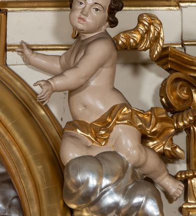 Zdjęcie nr 20: Dwukondygnacyjny, jednoosiowy ołtarz ze zwieńczeniem uzyskał strukturę architektoniczną. Stipes ołtarzowy wykonano w formie granitowego prostopadłościanu z mensą. Na mensie na osi ołtarza ustawiono tabernakulum z tronem wystawienia. Tabernakulum otrzymało kształt drewnianej skrzynki obitej blachą z drzwiczkami w formie stojącego prostokąta, z sześcioma kwaterami przedstawiającymi sceny z Pisma Świętego. Całość zamknięto silnie wysuniętym gzymsem wypukłym od frontu. Tron wystawienia utworzono w formie baldachimu ozdobionego lambrekinem z chwostami. Ujmują go spływy wolutowe z podwieszoną tkaniną, dekorowane liśćmi akantu. W przestrzeni zaplecka tronu umieszczono w promienistej glorii medalion z chrystogramem "IHS". Nastawa została ustawiona na wysokim cokole, zwieńczonym profilowanym gzymsem z wyodrębnionymi dwoma wspornikami skierowanymi do wewnątrz. Retabulum ujmuje  zwrócona na zewnątrz opilastrowana para filarów, przed którymi stoi para kolumn o kapitelach kompozytowych dźwigających pełne belkowanie wyłamane na ich osi. W polu centralnym znajduje się nisza w kształcie stojącego prostokąta zwieńczonego przerwanym prostokątnie łukiem półkolistym, nadwieszonym. Niszę obramienia profilowana rama. W jej wnętrzu znajduje się obraz Wniebowzięcia Najświętsze Marii Panny w drewnianych sukienkach wotywnych. Druga kondygnacja ujęta została dwiema parami zwróconych na zewnątrz pilastrów o trzonach przechodzących w spływy wolutowe. Pilastry dźwigają gzyms wyłamany na ich osi, który w części centralnej przyjmuje kształt spłaszczonego łuku. W polu umieszczono obraz z przedstawieniem Michała Archanioła w formie stojącego prostokąta o wklęsłych, dłuższych krawędziach oraz krótszych o kształcie łuku półkolistego nadwieszonego. Nastawa zakończona została okiem Opatrzności Bożej w glorii promienistej. Na cokole przed podporami ustawiono cztery figury adorujących aniołów. Ramę w polu środkowym udekorowano ornamentem roślinnym. W górnych przyłuczach umieszczono figury puttów na obłokach. Fryz został ozdobiony kwiatowymi girlandami. Centralnie na osi na gzymsie zawieszono kartusz z monogramem Marii w polu. Na zewnętrznych krawędziach belkowania pierwszej kondygnacji siedzą dwie figury aniołów, a na spływach wolutowych cztery putta. W trzonach pilastrów drugiej kondygnacji widoczne są zwisy z ornamentem kwiatowym podwieszonym na wstążce. W polu centralnym na dole umieszczono dwa wieńce, a u góry dwie uskrzydlone główki anielskie. Na belkowaniu znajdują się dwa putta na obłokach. Struktura nastawy została polichromowana w kolorze kości słoniowej, natomiast kolumny, pilastry, profile i ornamentyka zostały wyzłocone, a obłoki posrebrzone.