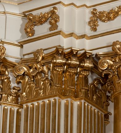 Zdjęcie nr 16: Dwukondygnacyjny, jednoosiowy ołtarz ze zwieńczeniem uzyskał strukturę architektoniczną. Stipes ołtarzowy wykonano w formie granitowego prostopadłościanu z mensą. Na mensie na osi ołtarza ustawiono tabernakulum z tronem wystawienia. Tabernakulum otrzymało kształt drewnianej skrzynki obitej blachą z drzwiczkami w formie stojącego prostokąta, z sześcioma kwaterami przedstawiającymi sceny z Pisma Świętego. Całość zamknięto silnie wysuniętym gzymsem wypukłym od frontu. Tron wystawienia utworzono w formie baldachimu ozdobionego lambrekinem z chwostami. Ujmują go spływy wolutowe z podwieszoną tkaniną, dekorowane liśćmi akantu. W przestrzeni zaplecka tronu umieszczono w promienistej glorii medalion z chrystogramem "IHS". Nastawa została ustawiona na wysokim cokole, zwieńczonym profilowanym gzymsem z wyodrębnionymi dwoma wspornikami skierowanymi do wewnątrz. Retabulum ujmuje  zwrócona na zewnątrz opilastrowana para filarów, przed którymi stoi para kolumn o kapitelach kompozytowych dźwigających pełne belkowanie wyłamane na ich osi. W polu centralnym znajduje się nisza w kształcie stojącego prostokąta zwieńczonego przerwanym prostokątnie łukiem półkolistym, nadwieszonym. Niszę obramienia profilowana rama. W jej wnętrzu znajduje się obraz Wniebowzięcia Najświętsze Marii Panny w drewnianych sukienkach wotywnych. Druga kondygnacja ujęta została dwiema parami zwróconych na zewnątrz pilastrów o trzonach przechodzących w spływy wolutowe. Pilastry dźwigają gzyms wyłamany na ich osi, który w części centralnej przyjmuje kształt spłaszczonego łuku. W polu umieszczono obraz z przedstawieniem Michała Archanioła w formie stojącego prostokąta o wklęsłych, dłuższych krawędziach oraz krótszych o kształcie łuku półkolistego nadwieszonego. Nastawa zakończona została okiem Opatrzności Bożej w glorii promienistej. Na cokole przed podporami ustawiono cztery figury adorujących aniołów. Ramę w polu środkowym udekorowano ornamentem roślinnym. W górnych przyłuczach umieszczono figury puttów na obłokach. Fryz został ozdobiony kwiatowymi girlandami. Centralnie na osi na gzymsie zawieszono kartusz z monogramem Marii w polu. Na zewnętrznych krawędziach belkowania pierwszej kondygnacji siedzą dwie figury aniołów, a na spływach wolutowych cztery putta. W trzonach pilastrów drugiej kondygnacji widoczne są zwisy z ornamentem kwiatowym podwieszonym na wstążce. W polu centralnym na dole umieszczono dwa wieńce, a u góry dwie uskrzydlone główki anielskie. Na belkowaniu znajdują się dwa putta na obłokach. Struktura nastawy została polichromowana w kolorze kości słoniowej, natomiast kolumny, pilastry, profile i ornamentyka zostały wyzłocone, a obłoki posrebrzone.