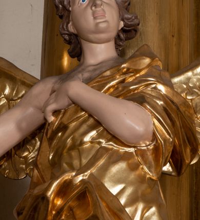 Zdjęcie nr 23: Dwukondygnacyjny, jednoosiowy ołtarz ze zwieńczeniem uzyskał strukturę architektoniczną. Stipes ołtarzowy wykonano w formie granitowego prostopadłościanu z mensą. Na mensie na osi ołtarza ustawiono tabernakulum z tronem wystawienia. Tabernakulum otrzymało kształt drewnianej skrzynki obitej blachą z drzwiczkami w formie stojącego prostokąta, z sześcioma kwaterami przedstawiającymi sceny z Pisma Świętego. Całość zamknięto silnie wysuniętym gzymsem wypukłym od frontu. Tron wystawienia utworzono w formie baldachimu ozdobionego lambrekinem z chwostami. Ujmują go spływy wolutowe z podwieszoną tkaniną, dekorowane liśćmi akantu. W przestrzeni zaplecka tronu umieszczono w promienistej glorii medalion z chrystogramem &quot;IHS&quot;. Nastawa została ustawiona na wysokim cokole, zwieńczonym profilowanym gzymsem z wyodrębnionymi dwoma wspornikami skierowanymi do wewnątrz. Retabulum ujmuje  zwrócona na zewnątrz opilastrowana para filarów, przed którymi stoi para kolumn o kapitelach kompozytowych dźwigających pełne belkowanie wyłamane na ich osi. W polu centralnym znajduje się nisza w kształcie stojącego prostokąta zwieńczonego przerwanym prostokątnie łukiem półkolistym, nadwieszonym. Niszę obramienia profilowana rama. W jej wnętrzu znajduje się obraz Wniebowzięcia Najświętsze Marii Panny w drewnianych sukienkach wotywnych. Druga kondygnacja ujęta została dwiema parami zwróconych na zewnątrz pilastrów o trzonach przechodzących w spływy wolutowe. Pilastry dźwigają gzyms wyłamany na ich osi, który w części centralnej przyjmuje kształt spłaszczonego łuku. W polu umieszczono obraz z przedstawieniem Michała Archanioła w formie stojącego prostokąta o wklęsłych, dłuższych krawędziach oraz krótszych o kształcie łuku półkolistego nadwieszonego. Nastawa zakończona została okiem Opatrzności Bożej w glorii promienistej. Na cokole przed podporami ustawiono cztery figury adorujących aniołów. Ramę w polu środkowym udekorowano ornamentem roślinnym. W górnych przyłuczach umieszczono figury puttów na obłokach. Fryz został ozdobiony kwiatowymi girlandami. Centralnie na osi na gzymsie zawieszono kartusz z monogramem Marii w polu. Na zewnętrznych krawędziach belkowania pierwszej kondygnacji siedzą dwie figury aniołów, a na spływach wolutowych cztery putta. W trzonach pilastrów drugiej kondygnacji widoczne są zwisy z ornamentem kwiatowym podwieszonym na wstążce. W polu centralnym na dole umieszczono dwa wieńce, a u góry dwie uskrzydlone główki anielskie. Na belkowaniu znajdują się dwa putta na obłokach. Struktura nastawy została polichromowana w kolorze kości słoniowej, natomiast kolumny, pilastry, profile i ornamentyka zostały wyzłocone, a obłoki posrebrzone.