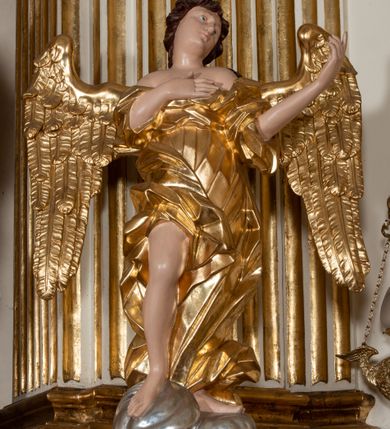 Zdjęcie nr 29: Dwukondygnacyjny, jednoosiowy ołtarz ze zwieńczeniem uzyskał strukturę architektoniczną. Stipes ołtarzowy wykonano w formie granitowego prostopadłościanu z mensą. Na mensie na osi ołtarza ustawiono tabernakulum z tronem wystawienia. Tabernakulum otrzymało kształt drewnianej skrzynki obitej blachą z drzwiczkami w formie stojącego prostokąta, z sześcioma kwaterami przedstawiającymi sceny z Pisma Świętego. Całość zamknięto silnie wysuniętym gzymsem wypukłym od frontu. Tron wystawienia utworzono w formie baldachimu ozdobionego lambrekinem z chwostami. Ujmują go spływy wolutowe z podwieszoną tkaniną, dekorowane liśćmi akantu. W przestrzeni zaplecka tronu umieszczono w promienistej glorii medalion z chrystogramem "IHS". Nastawa została ustawiona na wysokim cokole, zwieńczonym profilowanym gzymsem z wyodrębnionymi dwoma wspornikami skierowanymi do wewnątrz. Retabulum ujmuje  zwrócona na zewnątrz opilastrowana para filarów, przed którymi stoi para kolumn o kapitelach kompozytowych dźwigających pełne belkowanie wyłamane na ich osi. W polu centralnym znajduje się nisza w kształcie stojącego prostokąta zwieńczonego przerwanym prostokątnie łukiem półkolistym, nadwieszonym. Niszę obramienia profilowana rama. W jej wnętrzu znajduje się obraz Wniebowzięcia Najświętsze Marii Panny w drewnianych sukienkach wotywnych. Druga kondygnacja ujęta została dwiema parami zwróconych na zewnątrz pilastrów o trzonach przechodzących w spływy wolutowe. Pilastry dźwigają gzyms wyłamany na ich osi, który w części centralnej przyjmuje kształt spłaszczonego łuku. W polu umieszczono obraz z przedstawieniem Michała Archanioła w formie stojącego prostokąta o wklęsłych, dłuższych krawędziach oraz krótszych o kształcie łuku półkolistego nadwieszonego. Nastawa zakończona została okiem Opatrzności Bożej w glorii promienistej. Na cokole przed podporami ustawiono cztery figury adorujących aniołów. Ramę w polu środkowym udekorowano ornamentem roślinnym. W górnych przyłuczach umieszczono figury puttów na obłokach. Fryz został ozdobiony kwiatowymi girlandami. Centralnie na osi na gzymsie zawieszono kartusz z monogramem Marii w polu. Na zewnętrznych krawędziach belkowania pierwszej kondygnacji siedzą dwie figury aniołów, a na spływach wolutowych cztery putta. W trzonach pilastrów drugiej kondygnacji widoczne są zwisy z ornamentem kwiatowym podwieszonym na wstążce. W polu centralnym na dole umieszczono dwa wieńce, a u góry dwie uskrzydlone główki anielskie. Na belkowaniu znajdują się dwa putta na obłokach. Struktura nastawy została polichromowana w kolorze kości słoniowej, natomiast kolumny, pilastry, profile i ornamentyka zostały wyzłocone, a obłoki posrebrzone.