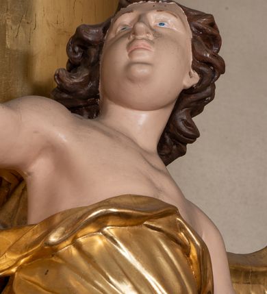 Zdjęcie nr 33: Dwukondygnacyjny, jednoosiowy ołtarz ze zwieńczeniem uzyskał strukturę architektoniczną. Stipes ołtarzowy wykonano w formie granitowego prostopadłościanu z mensą. Na mensie na osi ołtarza ustawiono tabernakulum z tronem wystawienia. Tabernakulum otrzymało kształt drewnianej skrzynki obitej blachą z drzwiczkami w formie stojącego prostokąta, z sześcioma kwaterami przedstawiającymi sceny z Pisma Świętego. Całość zamknięto silnie wysuniętym gzymsem wypukłym od frontu. Tron wystawienia utworzono w formie baldachimu ozdobionego lambrekinem z chwostami. Ujmują go spływy wolutowe z podwieszoną tkaniną, dekorowane liśćmi akantu. W przestrzeni zaplecka tronu umieszczono w promienistej glorii medalion z chrystogramem &quot;IHS&quot;. Nastawa została ustawiona na wysokim cokole, zwieńczonym profilowanym gzymsem z wyodrębnionymi dwoma wspornikami skierowanymi do wewnątrz. Retabulum ujmuje  zwrócona na zewnątrz opilastrowana para filarów, przed którymi stoi para kolumn o kapitelach kompozytowych dźwigających pełne belkowanie wyłamane na ich osi. W polu centralnym znajduje się nisza w kształcie stojącego prostokąta zwieńczonego przerwanym prostokątnie łukiem półkolistym, nadwieszonym. Niszę obramienia profilowana rama. W jej wnętrzu znajduje się obraz Wniebowzięcia Najświętsze Marii Panny w drewnianych sukienkach wotywnych. Druga kondygnacja ujęta została dwiema parami zwróconych na zewnątrz pilastrów o trzonach przechodzących w spływy wolutowe. Pilastry dźwigają gzyms wyłamany na ich osi, który w części centralnej przyjmuje kształt spłaszczonego łuku. W polu umieszczono obraz z przedstawieniem Michała Archanioła w formie stojącego prostokąta o wklęsłych, dłuższych krawędziach oraz krótszych o kształcie łuku półkolistego nadwieszonego. Nastawa zakończona została okiem Opatrzności Bożej w glorii promienistej. Na cokole przed podporami ustawiono cztery figury adorujących aniołów. Ramę w polu środkowym udekorowano ornamentem roślinnym. W górnych przyłuczach umieszczono figury puttów na obłokach. Fryz został ozdobiony kwiatowymi girlandami. Centralnie na osi na gzymsie zawieszono kartusz z monogramem Marii w polu. Na zewnętrznych krawędziach belkowania pierwszej kondygnacji siedzą dwie figury aniołów, a na spływach wolutowych cztery putta. W trzonach pilastrów drugiej kondygnacji widoczne są zwisy z ornamentem kwiatowym podwieszonym na wstążce. W polu centralnym na dole umieszczono dwa wieńce, a u góry dwie uskrzydlone główki anielskie. Na belkowaniu znajdują się dwa putta na obłokach. Struktura nastawy została polichromowana w kolorze kości słoniowej, natomiast kolumny, pilastry, profile i ornamentyka zostały wyzłocone, a obłoki posrebrzone.