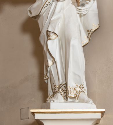 Zdjęcie nr 44: Dwukondygnacyjny, jednoosiowy ołtarz ze zwieńczeniem uzyskał strukturę architektoniczną. Stipes ołtarzowy wykonano w formie granitowego prostopadłościanu z mensą. Na mensie na osi ołtarza ustawiono tabernakulum z tronem wystawienia. Tabernakulum otrzymało kształt drewnianej skrzynki obitej blachą z drzwiczkami w formie stojącego prostokąta, z sześcioma kwaterami przedstawiającymi sceny z Pisma Świętego. Całość zamknięto silnie wysuniętym gzymsem wypukłym od frontu. Tron wystawienia utworzono w formie baldachimu ozdobionego lambrekinem z chwostami. Ujmują go spływy wolutowe z podwieszoną tkaniną, dekorowane liśćmi akantu. W przestrzeni zaplecka tronu umieszczono w promienistej glorii medalion z chrystogramem "IHS". Nastawa została ustawiona na wysokim cokole, zwieńczonym profilowanym gzymsem z wyodrębnionymi dwoma wspornikami skierowanymi do wewnątrz. Retabulum ujmuje  zwrócona na zewnątrz opilastrowana para filarów, przed którymi stoi para kolumn o kapitelach kompozytowych dźwigających pełne belkowanie wyłamane na ich osi. W polu centralnym znajduje się nisza w kształcie stojącego prostokąta zwieńczonego przerwanym prostokątnie łukiem półkolistym, nadwieszonym. Niszę obramienia profilowana rama. W jej wnętrzu znajduje się obraz Wniebowzięcia Najświętsze Marii Panny w drewnianych sukienkach wotywnych. Druga kondygnacja ujęta została dwiema parami zwróconych na zewnątrz pilastrów o trzonach przechodzących w spływy wolutowe. Pilastry dźwigają gzyms wyłamany na ich osi, który w części centralnej przyjmuje kształt spłaszczonego łuku. W polu umieszczono obraz z przedstawieniem Michała Archanioła w formie stojącego prostokąta o wklęsłych, dłuższych krawędziach oraz krótszych o kształcie łuku półkolistego nadwieszonego. Nastawa zakończona została okiem Opatrzności Bożej w glorii promienistej. Na cokole przed podporami ustawiono cztery figury adorujących aniołów. Ramę w polu środkowym udekorowano ornamentem roślinnym. W górnych przyłuczach umieszczono figury puttów na obłokach. Fryz został ozdobiony kwiatowymi girlandami. Centralnie na osi na gzymsie zawieszono kartusz z monogramem Marii w polu. Na zewnętrznych krawędziach belkowania pierwszej kondygnacji siedzą dwie figury aniołów, a na spływach wolutowych cztery putta. W trzonach pilastrów drugiej kondygnacji widoczne są zwisy z ornamentem kwiatowym podwieszonym na wstążce. W polu centralnym na dole umieszczono dwa wieńce, a u góry dwie uskrzydlone główki anielskie. Na belkowaniu znajdują się dwa putta na obłokach. Struktura nastawy została polichromowana w kolorze kości słoniowej, natomiast kolumny, pilastry, profile i ornamentyka zostały wyzłocone, a obłoki posrebrzone.