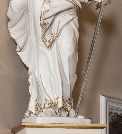 Zdjęcie nr 45: Dwukondygnacyjny, jednoosiowy ołtarz ze zwieńczeniem uzyskał strukturę architektoniczną. Stipes ołtarzowy wykonano w formie granitowego prostopadłościanu z mensą. Na mensie na osi ołtarza ustawiono tabernakulum z tronem wystawienia. Tabernakulum otrzymało kształt drewnianej skrzynki obitej blachą z drzwiczkami w formie stojącego prostokąta, z sześcioma kwaterami przedstawiającymi sceny z Pisma Świętego. Całość zamknięto silnie wysuniętym gzymsem wypukłym od frontu. Tron wystawienia utworzono w formie baldachimu ozdobionego lambrekinem z chwostami. Ujmują go spływy wolutowe z podwieszoną tkaniną, dekorowane liśćmi akantu. W przestrzeni zaplecka tronu umieszczono w promienistej glorii medalion z chrystogramem "IHS". Nastawa została ustawiona na wysokim cokole, zwieńczonym profilowanym gzymsem z wyodrębnionymi dwoma wspornikami skierowanymi do wewnątrz. Retabulum ujmuje  zwrócona na zewnątrz opilastrowana para filarów, przed którymi stoi para kolumn o kapitelach kompozytowych dźwigających pełne belkowanie wyłamane na ich osi. W polu centralnym znajduje się nisza w kształcie stojącego prostokąta zwieńczonego przerwanym prostokątnie łukiem półkolistym, nadwieszonym. Niszę obramienia profilowana rama. W jej wnętrzu znajduje się obraz Wniebowzięcia Najświętsze Marii Panny w drewnianych sukienkach wotywnych. Druga kondygnacja ujęta została dwiema parami zwróconych na zewnątrz pilastrów o trzonach przechodzących w spływy wolutowe. Pilastry dźwigają gzyms wyłamany na ich osi, który w części centralnej przyjmuje kształt spłaszczonego łuku. W polu umieszczono obraz z przedstawieniem Michała Archanioła w formie stojącego prostokąta o wklęsłych, dłuższych krawędziach oraz krótszych o kształcie łuku półkolistego nadwieszonego. Nastawa zakończona została okiem Opatrzności Bożej w glorii promienistej. Na cokole przed podporami ustawiono cztery figury adorujących aniołów. Ramę w polu środkowym udekorowano ornamentem roślinnym. W górnych przyłuczach umieszczono figury puttów na obłokach. Fryz został ozdobiony kwiatowymi girlandami. Centralnie na osi na gzymsie zawieszono kartusz z monogramem Marii w polu. Na zewnętrznych krawędziach belkowania pierwszej kondygnacji siedzą dwie figury aniołów, a na spływach wolutowych cztery putta. W trzonach pilastrów drugiej kondygnacji widoczne są zwisy z ornamentem kwiatowym podwieszonym na wstążce. W polu centralnym na dole umieszczono dwa wieńce, a u góry dwie uskrzydlone główki anielskie. Na belkowaniu znajdują się dwa putta na obłokach. Struktura nastawy została polichromowana w kolorze kości słoniowej, natomiast kolumny, pilastry, profile i ornamentyka zostały wyzłocone, a obłoki posrebrzone.