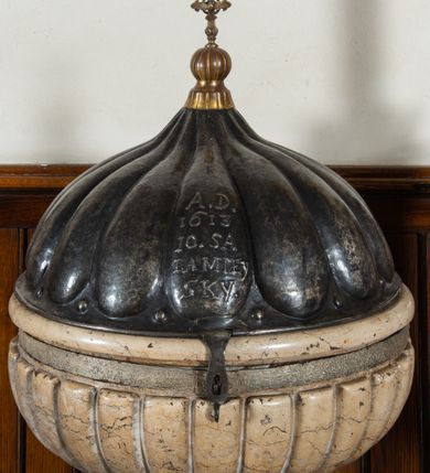 Zdjęcie nr 3: Marmurowa chrzcielnica uzyskała kształt kielicha. Na sześciennym cokole ustawiono czworoboczny postument, z którego wyrasta gruszkowa tralka podtrzymująca, spłaszczoną, sferyczną czarę dekorowaną imitacją płaskiego puklowania z wywiniętym brzegiem. Blaszana pokrywa uzyskała formę trybowanej półkuli, zakończonej aplikowaną kulą z krzyżem z gołębicą Ducha Świętego. Na pokrywie znajduje się trybowana inskrypcja: „A[NNO] D[OMINI] / 1613 /10.SA/LA MIEY/SKY&quot;.