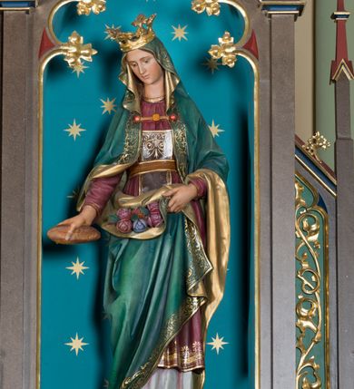 Zdjęcie nr 11: Wolnostojący, jednokondygnacyjny, trójosiowy ołtarz uzyskał formę architektoniczną ze zwieńczeniem. Stipes ołtarzowy przyjął formę leżącego prostopadłościanu ustawionego na podeście z dwoma gradusami, na którym wsparto drewnianą mensę z portatylem. Fronton stipesu podzielono za pomocą trzech płyciny, czworoboczną na osi, a w osiach skrajnych prostokątnymi. W płycinie pola środkowego umieszczono płaskorzeźbiony krzyż równoramienny wpisany w okręg. Natomiast w polach bocznych znalazły się ostrołukowe arkadki wypełnione malowanym i złoconym ornamentem roślinno-kwiatowym. Na mensie na osi ustawiono architektoniczne tabernakulum z tronem eucharystycznym. Jego dwuskrzydłowe drzwi ujęte zostały parą lizen, których płyciny wypełniono płaskorzeźbionym ornamentem. Drzwiczki ozdobiono płaskorzeźbioną dekoracją z winną latoroślą i srebrnymi literami „A” i „Ω”. Na lizenach wsparto niewielki, fazowany gzyms. Ponad nim usytuowano tron eucharystyczny w formie aediculi flankowanej złoconymi kolumnami na postumentach z liściastymi kapitelami podtrzymującymi imposty przechodzące w pinakle z kwiatonami. Pomiędzy nimi znalazła się wimperga z czołganiami i wieńczącym ją pinaklem z kwiatonem. Wimpergę wypełnia stylizowany łuk trójlistny. W niszy na tylnej ściance wykonano malarską dekorację z przedstawionym kielichem z jaśniejącym nad nim Najświętszym Sercem Pana Jezusa w koronie cierniowej, na tle dekoracji roślinnej. Całoś baldachimu nakrywa daszek siodłowy. Tabernakulum flankują dwa adorujące anioły w jasnych szatach ustawione na profilowanych postumentach dekorowanych na licu łacińskimi napisami &quot;Adoremus&quot; i &quot;Venite&quot;. Nastawa ołtarzowa ustawiona została na wysokim, dwustrefowym cokole. Górną strefę artykułowano za pomocą czworobocznych, zielonych płycin wypełnionych płaskorzeźbionym i złoconym ornamentem roślinnym, obramienionych profilowanymi listwami. Cokół zwieńczony został profilowanym gzymsem. Część środkowa nastawy jest wyższa i szersza od osi bocznych. Tworzy ją pole w kształcie stojącego prostokąta zamknięte u góry łukiem siodłowym, ujętego złoconą, profilowaną ramą. Pole flankują dwie smukłe kolumienki z liściastymi kapitelami, ustawione na postumentach, przechodzące w pinakle zwieńczone kwiatonami. Pomiędzy pinaklami usytuowano wimpergę wypełnioną maswerkiem z czterolistnym polem, w którym znajduje się napis:&quot;S[anc]t[us] Mrtinus&quot;. Wimpergę zakończoną pinaklem z kwiatonem zdobią czołgani. Ponad nią wypiętrzone zostało ażurowe zwieńczenie utworzone z podwójnych ostrołukowych arkadek flankujących fialę z kwiatonem. W polu kondygnacji prezentowany jest obraz ze św. Marcinem oraz dwa pozostałe na zasuwie z przedstawienie Madonny Sykstyńskiej oraz Matki Boskiej Nieustającej Pomocy. Poniżej pola obrazowego wprowadzono płycinę w kształcie leżącego prostokąta, dekorowaną malowaną, złoconą ornamentyką na zielonym tle. W osiach bocznych znalazły się dwie aedicule zwieńczone wimpergami z czołgankami i kwiatonem, flankowane parą wysmuklonych pinakli z kwiatonami. Górną część aediculi wypełnia arkatura. W niszach na niebieskim tle ze złotymi gwiazdami ustawiono figury św. Franciszka z Asyżu i św. Elżbiety z Turyngii. Kondygnację flankują ażurowe struktury utworzone z płycin ujętych smukłymi pinaklami, wypełnionymi płaskorzeźbionym ornamentem roślinnym. Struktura ołtarza polichromowana została w odcieniach zgaszonego brązu. Załamania profili architektonicznych pomalowano na czerwono, zielono i niebiesko, natomiast ornamenty wyzłocono. 