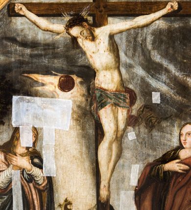 Zdjęcie nr 11: Obraz uzyskał formę stojącego prostokąta zamkniętego łukiem półkolistym nadwieszonym z uskokiem, ujętym w grubą, profilowana i złoconą ramę. W centrum kompozycji przedstawiono grupę Ukrzyżowania. Pod krzyżem, na którym wisi Chrystus stoi Matka Boska i św. Jan Ewangelista. Przybite do krzyża trzema gwoździami ciało Zbawiciela ukazane zostało w lekkim zwisie, o horyzontalnie rozłożonych ramionach. Jego głowa opada na prawe ramię, natomiast korpus wraz z nogami jest wygięty w lewo. Jezus ma wysokie czoło, mocno pociągłą twarz z zamkniętymi oczami, porostym nosem i małymi ustami. Twarz okala krótka, ciemna broda i ciemne włosy, które spływają na prawe ramię. Na głowie widoczna jest korona cierniowa otoczona świetlistymi promieniami. Spod niej ciekną strużki krwi. Jego biodra zakrywa rozwiane, krótkie perizonium z festonem przy prawym boku. Po prawej stronie krzyża wyobrażono Marię w całej postaci, zwróconą w trzech czwartych w prawo, z pochyloną głową i dłońmi skrzyżowanymi na piersi. Madonna ma owalną twarz z dużymi, migdałowatymi oczami zwróconymi ku górze, prosty nos i pełne, rozchylone usta. Wokół głowy widoczny jest nimb. Maria ubrana jest w bladoszkarłatną suknię z widocznymi białymi rękawami spodniej koszuli oraz narzucony na ramiona szaro-niebieski płaszcz z prawą połą przerzuconą przez ręce. Na głowie ma ciemnoochrową chustę owiniętą wokół szyi. Po lewej stronie krzyża ukazano w całej postaci w kontrapoście św. Jan, zwróconego w trzech czwartych w lewo. Apostoł prawą dłonią dotyka piersi, lewą zaś ma odsuniętą od siebie w bok. Jego twarz jest owalna, o dużych, okrągłych oczach, prostym nosie, pełnych ustach, okolona długimi jasnobrązowymi włosami spływającymi na ramiona. Głowę ucznia Jezusa okala nimb. Święty ubrany jest w luźną, ciemnobrązową tunikę oraz długi, fioletowo-brązowy, rozwiany płaszcz. Postacie zostały ukazane na tle pejzażu z widoczną architekturą miasta. W górnej części obrazu widoczne jest ciemne, zachmurzone niebo ze znajdującym się po prawej stronie krzyża zaćmionym słońcem, a po lewo z czerwonym sierpem księżyca. U dołu pionowej belki krzyża widnieje napis: „1695 / R[E]N[OWATUM] / 1703”. Powyżej półkolistego zamknięcia kompozycji w przyłuczach znajduje się ryty w zaprawie i złocony ornament roślinny. 