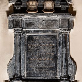 Zdjęcie nr 1: Epitafium w kształcie prostokątnej tablicy, wspartej na profilowanym gzymsie, ujętej kolumienkami jońskimi podtrzymującymi wyłamujące się ponad nimi belkowanie. Po bokach kolumn dostawione spływy wolutowe. Nad belkowaniem fryz z dwiema (odwróconymi) tarczami. W nich kolejne tarcze, również odwrócone, z godłami herbów Godziemba i Zadora. Nad tarczami korony rangowe (hrabiowskie) z klejnotami herbowymi. Nad fryzem przerwany, łukowato zarysowany przyczółek, wewnątrz którego cokolik z krzyżem o rozszerzających się ramionach. W polu inskrypcja „Mikołajowi / z Lubrańca Godziembie / DĄMBSKIEMU / * 10 Wrześ(nia) 1778 w Nieszkowie. / + 18 Paźdz(iernika) 1868 w Wiesbadenie / i Żonie Jego Leokadyi / z Brzezia Russockich / DĄMBSKIEJ / * 14 Marc(a) 1806 w Oświęcimie / + 27 Czerwca 1870 r(oku) / Właścicielom Oświęcimia / Wdzięczne dzieci / proszą dla Nich o Zdrowaś Marya”. W dolnej części, po prawej stronie sygnatura „E(dward) Stehlik / w Krakowie”.