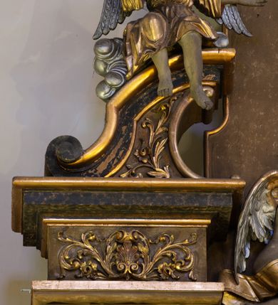 Zdjęcie nr 5: Jednokondygnacyjny, jednoosiowy ołtarz przyścienny ze zwieńczeniem uzyskał strukturę architektoniczną. Stipes ołtarzowy wykonano w formie wklęsło-wypukłego sarkofagu, zwężającego się ku dołowi, ujętego akantowymi wolutami. Na jego licu w centrum umieszczono płaskorzeźbiony medalion z monogramem maryjnym, ujęty symetryczną dekoracją roślinną, utworzoną z wici akantu oraz kwiatów. Retabulum zostało ustawione na wysokim, dwudzielnym cokole. Cokół zwieńczony profilowanym gzymsem udekorowano płycinami, które w wyższej kondygnacji wypełnione zostały dekoracją akantową. Nastawa po bokach ujęta została zdwojonymi kolumnami, umieszczonymi na prostopadłościennych postumentach z  symetryczną dekoracją utworzoną z akantu i kwiatów. Kapitele kolumn są kompozytowe, zaś trzony do jednej trzeciej wysokości zdobione zostały kanelurami. Kolumny podtrzymują odcinki pełnego belkowania, na których umieszczone są odcinki przerwanego przyczółka z umieszczonymi na nich figurami aniołów. Zwieńczenie ma formę zbliżoną do prostokąta zamkniętego od góry antytetycznie ustawionymi wolutami. Pomiędzy nimi na osi umieszczono na tle glorii promienistej złocony krzyż o trójlistnie zakończonych ramionach. W polu ołtarza usytuowano płycinę zamkniętą łukiem nadwieszonym z obrazem Matki Boskiej Szkaplerznej z Dzieciątkiem. Ponad obrazem znalazły się dwie rzeźbione figury aniołów podtrzymujących koronę oraz złoconą banderole z napisem: &quot;ZDROWAŚ  MARIO&quot;. W zwieńczeniu umieszczono obraz św. Floriana w kształcie stojącego prostokąta o wklęsłych bokach, ściętych narożach i zamkniętego łukiem wklęsło-wypukłym. Struktura ołtarza została polichromowana w odcieniach brązu i czerni, natomiast ornamentykę i detale architektoniczne wyzłocono.