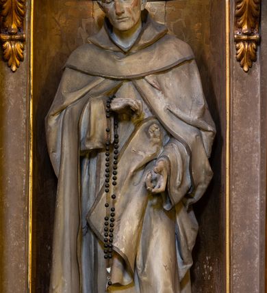 Zdjęcie nr 5: Dwukondygnacyjny, trójosiowy ołtarz przyścienny ze zwieńczeniem uzyskał strukturę architektoniczną. Stipes ołtarzowy wykonano w formie stołu z mensą wspartą na dwóch parach filarów z kanelurą zwężających się ku dołowi,  ustawionych na postumentach z przodu i z tyłu. Pomiędzy tylnią parą wprowadzono płycinę w kształcie leżącego prostokąta. W jej pole wpisano płaskorzeźbiony krzyż równoramienny w czteroliściu obramieniony profilowanymi ramkami. Nastawę ołtarza umieszczona na wysokim cokole, zwieńczonym profilowanym gzymsem. Na osi na mensie ustawiono architektoniczne tabernakulum, ujęte ustawionymi ukośnie kolumienkami, dźwigającymi odcinki pełnego belkowania, zwieńczone daszkiem w kształcie ściętego ostrosłupa z tronem wystawienia. Na drzwiczkach namalowano kielich z hostią w złoconej płycinie. Powyżej drzwiczek ukazano płaskorzeźbioną, uskrzydloną główkę aniołka. Nastawa została artykułowana kompozytowymi kolumnami o gładkich, złoconych trzonach, ustawionymi na występujących przed lico ołtarza prostopadłościennych postumentach, dekorowanych  płaskorzeźbionymi festonami. Kolumny dolnej kondygnacji podtrzymują pełne belkowanie z rozbudowanym fryzem, dekorowanym płycinami, wypełnionymi wicią akantową, kwiatami oraz uskrzydlonymi główkami anielskimi. Belkowanie wieńczy rozbudowany, silnie wystający, profilowany gzyms. Także kondygnację drugą ujęto parą kolumn analogicznych jak w kondygnacji pierwszej, a po bokach zamknięto ją akantowymi spływami wolutowymi. Kolumny podtrzymują pełne belkowanie z fryzem dekorowanym kartuszami, rozetą, kwiatami oraz profilowany gzyms. Zwieńczenie retabulum wykonano w formie przerwanego przyczółka o linii łuku odcinkowego z umieszczonym na osi złoconym krzyżem na tle glorii promienistej. W kondygnacji pierwszej w osi środkowej znalazła się prostokątna płycina mieszcząca obraz Matki Boskiej z Dzieciątkiem. W osiach skrajnych usytuowano zamknięte półkoliście nisze, dekorowane muszlą palmetową, mieszczące pełnoplastyczne figury. Z lewej ustawiono rzeźbę św. Franciszka, a z prawej św. Dominika. Także w kondygnacji drugiej umieszczono na osi płycinę w kształcie stojącego prostokąta zamkniętą półkoliście, w której zainstalowano obraz przedstawiający wizję św. Franciszka. Ołtarz został polichromowany w odcieniach brązu, natomiast ornamentykę i detale architektoniczne pozłocono.