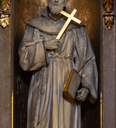 Zdjęcie nr 4: Dwukondygnacyjny, trójosiowy ołtarz przyścienny ze zwieńczeniem uzyskał strukturę architektoniczną. Stipes ołtarzowy wykonano w formie stołu z mensą wspartą na dwóch parach filarów z kanelurą zwężających się ku dołowi,  ustawionych na postumentach z przodu i z tyłu. Pomiędzy tylnią parą wprowadzono płycinę w kształcie leżącego prostokąta. W jej pole wpisano płaskorzeźbiony krzyż równoramienny w czteroliściu obramieniony profilowanymi ramkami. Nastawę ołtarza umieszczona na wysokim cokole, zwieńczonym profilowanym gzymsem. Na osi na mensie ustawiono architektoniczne tabernakulum, ujęte ustawionymi ukośnie kolumienkami, dźwigającymi odcinki pełnego belkowania, zwieńczone daszkiem w kształcie ściętego ostrosłupa z tronem wystawienia. Na drzwiczkach namalowano kielich z hostią w złoconej płycinie. Powyżej drzwiczek ukazano płaskorzeźbioną, uskrzydloną główkę aniołka. Nastawa została artykułowana kompozytowymi kolumnami o gładkich, złoconych trzonach, ustawionymi na występujących przed lico ołtarza prostopadłościennych postumentach, dekorowanych  płaskorzeźbionymi festonami. Kolumny dolnej kondygnacji podtrzymują pełne belkowanie z rozbudowanym fryzem, dekorowanym płycinami, wypełnionymi wicią akantową, kwiatami oraz uskrzydlonymi główkami anielskimi. Belkowanie wieńczy rozbudowany, silnie wystający, profilowany gzyms. Także kondygnację drugą ujęto parą kolumn analogicznych jak w kondygnacji pierwszej, a po bokach zamknięto ją akantowymi spływami wolutowymi. Kolumny podtrzymują pełne belkowanie z fryzem dekorowanym kartuszami, rozetą, kwiatami oraz profilowany gzyms. Zwieńczenie retabulum wykonano w formie przerwanego przyczółka o linii łuku odcinkowego z umieszczonym na osi złoconym krzyżem na tle glorii promienistej. W kondygnacji pierwszej w osi środkowej znalazła się prostokątna płycina mieszcząca obraz Matki Boskiej z Dzieciątkiem. W osiach skrajnych usytuowano zamknięte półkoliście nisze, dekorowane muszlą palmetową, mieszczące pełnoplastyczne figury. Z lewej ustawiono rzeźbę św. Franciszka, a z prawej św. Dominika. Także w kondygnacji drugiej umieszczono na osi płycinę w kształcie stojącego prostokąta zamkniętą półkoliście, w której zainstalowano obraz przedstawiający wizję św. Franciszka. Ołtarz został polichromowany w odcieniach brązu, natomiast ornamentykę i detale architektoniczne pozłocono.