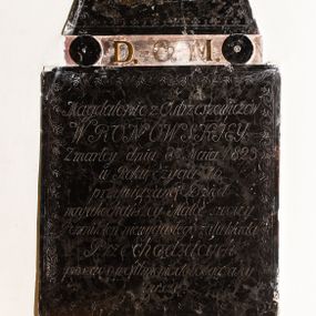 Zdjęcie nr 1: Płytowe epitafium ścienne składa się z trzech zasadniczych części - konsoli, płyty właściwej i zwieńczenia. Całość wspiera się na prostopadłościennej konsoli mającej formę leżącego, wydłużonego prostokąta. Na niej ustawiono czworoboczną płytę z inskrypcją wspartą na dwóch trapezoidalnych nóżkach, z dłuższym bokiem u góry. Płytę przy krawędziach ozdobiono ornamentem roślinnym tworzącym dekoracyjną bordiurę. Pole w całości wypełnia napis: "Magdalenie z Ostrzeszewiczów / WRONOWSKIEY / Zmarłey dnia 8[ósme]go Maia 1823 / w Roku życia 76 / przywiązane Dzieci / nayukochańszey Matce swoiey / Pomnik ten niewygasłego żalu kładą / Przechodzących / prosząc o westchnienie do Boga za Jey / Duszę". Na płycie wsparto na okrągłych podporach, pierwotnie zdobionych aplikacjami z brązu, zwieńczenie w formie płaskiego obelisku o ściętym wierzchołku. Jego pole zdobi profilowane obramienie oraz ryta arkatura. Na szczycie znajduje się półwypukła waza. Pomiędzy podporami obelisku umieszczono wykonane z brązu litery: "D[eo] O[pitmo] M[aximo]".