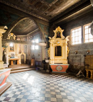 Zdjęcie nr 5: Kościół stanowi orientowaną, drewnianą świątynie wzniesioną na zrąb w układzie salowym z nawą na rzucie zbliżonym do kwadratu. Od wschody do nawy przylega węższe, prostokątne prezbiterium zamknięte trójbocznie. Od północy do prezbiterium dostawiono drewnianą zakrystię połączoną za pomocą portalu z prezbiterium kościoła. Do nawy od zachodu dostawiono czworoboczną wieżę o pochyłych ścianach, wzniesioną w konstrukcji słupowej. Wieńczy ją nadwieszona, czworoboczna izbica z ostrosłupowym, gontowym hełmem z krzyżem. W przyziemiach wieży urządzono kruchtę połączoną z nawą świątyni. Od północy, wschodu i południa kościół otaczają otwarte soboty, szalowane przy wieży. Elewacje zewnętrze zostały oszalowane lub też pokryte gontem. W nawie i prezbiterium przepruto okna parzyste, czworoboczne. Całość nakrywa dach gontowy o jednej kalenicy. Nad nawą w części wschodniej nadwieszono wieloboczną sygnaturkę w formie latarni z baniastym hełmem. Wnętrze nakryto stropami, dodatków w nawie z zaskrzynieniami. Pomiędzy prezbiterium, a nawą rozpięta jest ostrołukowa tęcza z fazowaną belką zawieszoną na kroksztynach z ustawionym na osi krucyfiksem. W zachodniej części nawy urządzono chór muzyczny o drewnianym, pełnym parapecie wklęsło-wypukłym z lambrekinem, wspartym na dwóch żłobkowanych kolumnach. Odrzwia południowe prowadzące do nawy ujęto w portal wycięty w ośli grzbiet. W prezbiterium ustawiono ołtarz główny, a w nawie dwa ołtarze boczne. 