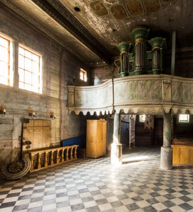 Zdjęcie nr 8: Kościół stanowi orientowaną, drewnianą świątynie wzniesioną na zrąb w układzie salowym z nawą na rzucie zbliżonym do kwadratu. Od wschody do nawy przylega węższe, prostokątne prezbiterium zamknięte trójbocznie. Od północy do prezbiterium dostawiono drewnianą zakrystię połączoną za pomocą portalu z prezbiterium kościoła. Do nawy od zachodu dostawiono czworoboczną wieżę o pochyłych ścianach, wzniesioną w konstrukcji słupowej. Wieńczy ją nadwieszona, czworoboczna izbica z ostrosłupowym, gontowym hełmem z krzyżem. W przyziemiach wieży urządzono kruchtę połączoną z nawą świątyni. Od północy, wschodu i południa kościół otaczają otwarte soboty, szalowane przy wieży. Elewacje zewnętrze zostały oszalowane lub też pokryte gontem. W nawie i prezbiterium przepruto okna parzyste, czworoboczne. Całość nakrywa dach gontowy o jednej kalenicy. Nad nawą w części wschodniej nadwieszono wieloboczną sygnaturkę w formie latarni z baniastym hełmem. Wnętrze nakryto stropami, dodatków w nawie z zaskrzynieniami. Pomiędzy prezbiterium, a nawą rozpięta jest ostrołukowa tęcza z fazowaną belką zawieszoną na kroksztynach z ustawionym na osi krucyfiksem. W zachodniej części nawy urządzono chór muzyczny o drewnianym, pełnym parapecie wklęsło-wypukłym z lambrekinem, wspartym na dwóch żłobkowanych kolumnach. Odrzwia południowe prowadzące do nawy ujęto w portal wycięty w ośli grzbiet. W prezbiterium ustawiono ołtarz główny, a w nawie dwa ołtarze boczne. 