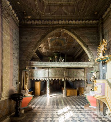 Zdjęcie nr 10: Kościół stanowi orientowaną, drewnianą świątynie wzniesioną na zrąb w układzie salowym z nawą na rzucie zbliżonym do kwadratu. Od wschody do nawy przylega węższe, prostokątne prezbiterium zamknięte trójbocznie. Od północy do prezbiterium dostawiono drewnianą zakrystię połączoną za pomocą portalu z prezbiterium kościoła. Do nawy od zachodu dostawiono czworoboczną wieżę o pochyłych ścianach, wzniesioną w konstrukcji słupowej. Wieńczy ją nadwieszona, czworoboczna izbica z ostrosłupowym, gontowym hełmem z krzyżem. W przyziemiach wieży urządzono kruchtę połączoną z nawą świątyni. Od północy, wschodu i południa kościół otaczają otwarte soboty, szalowane przy wieży. Elewacje zewnętrze zostały oszalowane lub też pokryte gontem. W nawie i prezbiterium przepruto okna parzyste, czworoboczne. Całość nakrywa dach gontowy o jednej kalenicy. Nad nawą w części wschodniej nadwieszono wieloboczną sygnaturkę w formie latarni z baniastym hełmem. Wnętrze nakryto stropami, dodatków w nawie z zaskrzynieniami. Pomiędzy prezbiterium, a nawą rozpięta jest ostrołukowa tęcza z fazowaną belką zawieszoną na kroksztynach z ustawionym na osi krucyfiksem. W zachodniej części nawy urządzono chór muzyczny o drewnianym, pełnym parapecie wklęsło-wypukłym z lambrekinem, wspartym na dwóch żłobkowanych kolumnach. Odrzwia południowe prowadzące do nawy ujęto w portal wycięty w ośli grzbiet. W prezbiterium ustawiono ołtarz główny, a w nawie dwa ołtarze boczne. 