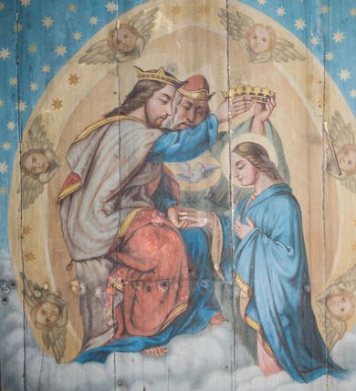 Zdjęcie nr 2: Dekoracją malarską pokryto fasety, stropy w nawie i prezbiterium, a także ich ściany oraz przestrzeń przedsionka pod wieżą. Ściany prezbiterium, nawy i przedsionka artykułowano za pomocą malowanych pilastrów o korynckich głowicach ustawionych na wysokich postumentach, podtrzymujących belkowanie. Pomiędzy pilastrami wprowadzono malowane czworoboczne płyciny o wklęsłych narożach z polem pokrytym marmoryzacją. Wąską fasetę podstropową ozdobiono fryzem z rytmicznie powtarzającym się motywem liścia palmetowego. Strop w prezbiterium i nawie uzyskał architektoniczne obramienie sceny centralnej ujętej w prostokątne pole o zaokrąglonych narożach, utworzone z iluzjonistycznie malowanych listew i zawieszonych pomiędzy nimi girland liściastych. W prezbiterium wyobrażono Trójcę Świętą, a w nawie Koronację Marii obwiedzioną tajemnicami różańcowymi w medalionach. Trójcę Świętą ukazano na obłokach na niebieskim tle. Majestatyczny Bóg Ojciec został ukazany w trzech czwartych w lewo jako siwobrody starzec o bujnych siwych włosach. W prawej ręce trzyma złote berło, lewą zaś odsuwa do siebie. Bóg Ojciec stopy wspiera o niebieski glob wyłaniający się z obłoków poniżej. Jego twarz charakteryzuje jasna karnacja, szeroko otwarte oczy, wydatny nos i usta. Głowę otacza długa, siwa broda i podobne włosy. Ubrany jest w mocno drapowaną białą tunikę i narzucony na nią rozwiany, złocisty płaszcz obszyty dekoracyjną bortą, spięty klamrą na lewym ramieniu. Obok Boga Ojca z lewej strony siedzi Chrystus, który obie, skrzyżowane nogi wspiera na globie. Zbawiciel prawą ręką podtrzymuje oparty o ramię drewniany krzyż, lewą zaś ma odsuniętą od siebie z gestem wskazującym na Ojca. Jezus został przedstawiony w trzech czwartych w prawo. Jest to dojrzały mężczyzna o pociągłej twarzy okolonej brązowymi, długimi włosami spływającymi na ramiona oraz brodą. Ma jasną karnację, prosty nos i wydatne usta. Nagi tors okrywa bladoszkarłatny płaszcz odsłaniający obie stopy Na dłoniach i stopach widoczne są rany po gwoździach. Głowę Jezusa okala świetlisty nimb. Powyżej obu postaci na tle rozjaśnionego nieba unosi się gołębica Ducha Świętego w promienistym otoku. Koronację Marii otoczoną przez owalne  medaliony ze scenami różańcowymi namalowano w polu dekoracyjnego, wydłużonego czworobocznego panneau o narożach utworzonych z roślinnego ornamentu powtórzonego symetrycznie na dłuższych bokach w środku. W centrum czworoboku o zaokrąglonych narożach obwiedzionych motywem różańca przedstawiono klęczącą na obłokach Marię przed koronującą ją Trójcą Świętą. Madonna jako młoda dziewczyna ujęta została w profilu w lewo. Lewą rękę ma przyłożoną do piersi, prawą zaś podaje synowi. Jej owalna twarz ma jasną karnację o wydatnym nosie i ustach. Głowę otaczają brązowe włosy spływające na plecy. Maria ubrana jest w lamowany złotą taśmą niebieski połaszcz oraz fragmentarycznie widoczną czerwoną suknię. Przed nią siedzi Chrystus, a za nim Bóg Ojciec. Pomiędzy nimi widać w jasnym otoku gołębicę Ducha Świętego. Jezus został ujęty w profilu w prawo. Prawą ręką unosi wraz Ojcem złotą koronę nad głową matki. Lewą zaś wspartą na kolanie trzyma jej prawą dłoń. Chrystus ma pociągłą twarz o jasnej karnacji i rumianych policzkach, wydatny nos i usta. Jego głowę otaczają długie brązowe włosy spływające na plecy oraz krótki zarost. Na głowie ma złoty diadem. Ubrany jest w niebieską tunikę i czerwony, mocno wywinięty płaszcz o jasnobeżowej podszewce. Spod tuniki widać fragmenty bosych stóp wspartych na obłokach. Obok Zbawiciela fragmentarycznie widać postać Boga Ojca ujętego frontalnie. Jest to starszy mężczyzna o siwym, obfitym zaroście i włosach. Ma wydatny nos i usta, a na głowie złoty diadem w formie mitry. Postacie ujmuje złocista, migdałowa mandorla utworzona z jasnego obramienia, na którym ukazano uskrzydlone główki serafinów. Dolną część mandorli spowijają obłoki. Całość ukazano na niebieskim tle usianym gwiazdami. Wokół centralnego przedstawienia rozmieszczono czternaście owalnych medalionów różańcowych. Ich narracja rozpoczyna się na osi ponad sceną z koronacją Marii. Idąc w lewo namalowano: Zwiastowanie Marii, Nawiedzenie św. Elżbiety, Boże Narodzenie, Ofiarowanie w świątyni, Znalezienie w świątyni, Modlitwa w Ogrójcu, Biczowanie, Cierniem ukoronowanie, Niesienie krzyża, Ukrzyżowanie, Zmartwychwstanie, Wniebowstąpienie, Zesłanie Ducha Świętego i Wniebowzięcie Marii. Pomiędzy medalionami namalowano czerwone róże.    