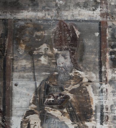 Zdjęcie nr 18: Dekoracją malarską pokryto fasety, stropy w nawie i prezbiterium, a także ich ściany oraz przestrzeń przedsionka pod wieżą. Ściany prezbiterium, nawy i przedsionka artykułowano za pomocą malowanych pilastrów o korynckich głowicach ustawionych na wysokich postumentach, podtrzymujących belkowanie. Pomiędzy pilastrami wprowadzono malowane czworoboczne płyciny o wklęsłych narożach z polem pokrytym marmoryzacją. Wąską fasetę podstropową ozdobiono fryzem z rytmicznie powtarzającym się motywem liścia palmetowego. Strop w prezbiterium i nawie uzyskał architektoniczne obramienie sceny centralnej ujętej w prostokątne pole o zaokrąglonych narożach, utworzone z iluzjonistycznie malowanych listew i zawieszonych pomiędzy nimi girland liściastych. W prezbiterium wyobrażono Trójcę Świętą, a w nawie Koronację Marii obwiedzioną tajemnicami różańcowymi w medalionach. Trójcę Świętą ukazano na obłokach na niebieskim tle. Majestatyczny Bóg Ojciec został ukazany w trzech czwartych w lewo jako siwobrody starzec o bujnych siwych włosach. W prawej ręce trzyma złote berło, lewą zaś odsuwa do siebie. Bóg Ojciec stopy wspiera o niebieski glob wyłaniający się z obłoków poniżej. Jego twarz charakteryzuje jasna karnacja, szeroko otwarte oczy, wydatny nos i usta. Głowę otacza długa, siwa broda i podobne włosy. Ubrany jest w mocno drapowaną białą tunikę i narzucony na nią rozwiany, złocisty płaszcz obszyty dekoracyjną bortą, spięty klamrą na lewym ramieniu. Obok Boga Ojca z lewej strony siedzi Chrystus, który obie, skrzyżowane nogi wspiera na globie. Zbawiciel prawą ręką podtrzymuje oparty o ramię drewniany krzyż, lewą zaś ma odsuniętą od siebie z gestem wskazującym na Ojca. Jezus został przedstawiony w trzech czwartych w prawo. Jest to dojrzały mężczyzna o pociągłej twarzy okolonej brązowymi, długimi włosami spływającymi na ramiona oraz brodą. Ma jasną karnację, prosty nos i wydatne usta. Nagi tors okrywa bladoszkarłatny płaszcz odsłaniający obie stopy Na dłoniach i stopach widoczne są rany po gwoździach. Głowę Jezusa okala świetlisty nimb. Powyżej obu postaci na tle rozjaśnionego nieba unosi się gołębica Ducha Świętego w promienistym otoku. Koronację Marii otoczoną przez owalne  medaliony ze scenami różańcowymi namalowano w polu dekoracyjnego, wydłużonego czworobocznego panneau o narożach utworzonych z roślinnego ornamentu powtórzonego symetrycznie na dłuższych bokach w środku. W centrum czworoboku o zaokrąglonych narożach obwiedzionych motywem różańca przedstawiono klęczącą na obłokach Marię przed koronującą ją Trójcą Świętą. Madonna jako młoda dziewczyna ujęta została w profilu w lewo. Lewą rękę ma przyłożoną do piersi, prawą zaś podaje synowi. Jej owalna twarz ma jasną karnację o wydatnym nosie i ustach. Głowę otaczają brązowe włosy spływające na plecy. Maria ubrana jest w lamowany złotą taśmą niebieski połaszcz oraz fragmentarycznie widoczną czerwoną suknię. Przed nią siedzi Chrystus, a za nim Bóg Ojciec. Pomiędzy nimi widać w jasnym otoku gołębicę Ducha Świętego. Jezus został ujęty w profilu w prawo. Prawą ręką unosi wraz Ojcem złotą koronę nad głową matki. Lewą zaś wspartą na kolanie trzyma jej prawą dłoń. Chrystus ma pociągłą twarz o jasnej karnacji i rumianych policzkach, wydatny nos i usta. Jego głowę otaczają długie brązowe włosy spływające na plecy oraz krótki zarost. Na głowie ma złoty diadem. Ubrany jest w niebieską tunikę i czerwony, mocno wywinięty płaszcz o jasnobeżowej podszewce. Spod tuniki widać fragmenty bosych stóp wspartych na obłokach. Obok Zbawiciela fragmentarycznie widać postać Boga Ojca ujętego frontalnie. Jest to starszy mężczyzna o siwym, obfitym zaroście i włosach. Ma wydatny nos i usta, a na głowie złoty diadem w formie mitry. Postacie ujmuje złocista, migdałowa mandorla utworzona z jasnego obramienia, na którym ukazano uskrzydlone główki serafinów. Dolną część mandorli spowijają obłoki. Całość ukazano na niebieskim tle usianym gwiazdami. Wokół centralnego przedstawienia rozmieszczono czternaście owalnych medalionów różańcowych. Ich narracja rozpoczyna się na osi ponad sceną z koronacją Marii. Idąc w lewo namalowano: Zwiastowanie Marii, Nawiedzenie św. Elżbiety, Boże Narodzenie, Ofiarowanie w świątyni, Znalezienie w świątyni, Modlitwa w Ogrójcu, Biczowanie, Cierniem ukoronowanie, Niesienie krzyża, Ukrzyżowanie, Zmartwychwstanie, Wniebowstąpienie, Zesłanie Ducha Świętego i Wniebowzięcie Marii. Pomiędzy medalionami namalowano czerwone róże.    