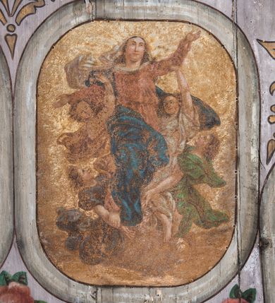 Zdjęcie nr 6: Dekoracją malarską pokryto fasety, stropy w nawie i prezbiterium, a także ich ściany oraz przestrzeń przedsionka pod wieżą. Ściany prezbiterium, nawy i przedsionka artykułowano za pomocą malowanych pilastrów o korynckich głowicach ustawionych na wysokich postumentach, podtrzymujących belkowanie. Pomiędzy pilastrami wprowadzono malowane czworoboczne płyciny o wklęsłych narożach z polem pokrytym marmoryzacją. Wąską fasetę podstropową ozdobiono fryzem z rytmicznie powtarzającym się motywem liścia palmetowego. Strop w prezbiterium i nawie uzyskał architektoniczne obramienie sceny centralnej ujętej w prostokątne pole o zaokrąglonych narożach, utworzone z iluzjonistycznie malowanych listew i zawieszonych pomiędzy nimi girland liściastych. W prezbiterium wyobrażono Trójcę Świętą, a w nawie Koronację Marii obwiedzioną tajemnicami różańcowymi w medalionach. Trójcę Świętą ukazano na obłokach na niebieskim tle. Majestatyczny Bóg Ojciec został ukazany w trzech czwartych w lewo jako siwobrody starzec o bujnych siwych włosach. W prawej ręce trzyma złote berło, lewą zaś odsuwa do siebie. Bóg Ojciec stopy wspiera o niebieski glob wyłaniający się z obłoków poniżej. Jego twarz charakteryzuje jasna karnacja, szeroko otwarte oczy, wydatny nos i usta. Głowę otacza długa, siwa broda i podobne włosy. Ubrany jest w mocno drapowaną białą tunikę i narzucony na nią rozwiany, złocisty płaszcz obszyty dekoracyjną bortą, spięty klamrą na lewym ramieniu. Obok Boga Ojca z lewej strony siedzi Chrystus, który obie, skrzyżowane nogi wspiera na globie. Zbawiciel prawą ręką podtrzymuje oparty o ramię drewniany krzyż, lewą zaś ma odsuniętą od siebie z gestem wskazującym na Ojca. Jezus został przedstawiony w trzech czwartych w prawo. Jest to dojrzały mężczyzna o pociągłej twarzy okolonej brązowymi, długimi włosami spływającymi na ramiona oraz brodą. Ma jasną karnację, prosty nos i wydatne usta. Nagi tors okrywa bladoszkarłatny płaszcz odsłaniający obie stopy Na dłoniach i stopach widoczne są rany po gwoździach. Głowę Jezusa okala świetlisty nimb. Powyżej obu postaci na tle rozjaśnionego nieba unosi się gołębica Ducha Świętego w promienistym otoku. Koronację Marii otoczoną przez owalne  medaliony ze scenami różańcowymi namalowano w polu dekoracyjnego, wydłużonego czworobocznego panneau o narożach utworzonych z roślinnego ornamentu powtórzonego symetrycznie na dłuższych bokach w środku. W centrum czworoboku o zaokrąglonych narożach obwiedzionych motywem różańca przedstawiono klęczącą na obłokach Marię przed koronującą ją Trójcą Świętą. Madonna jako młoda dziewczyna ujęta została w profilu w lewo. Lewą rękę ma przyłożoną do piersi, prawą zaś podaje synowi. Jej owalna twarz ma jasną karnację o wydatnym nosie i ustach. Głowę otaczają brązowe włosy spływające na plecy. Maria ubrana jest w lamowany złotą taśmą niebieski połaszcz oraz fragmentarycznie widoczną czerwoną suknię. Przed nią siedzi Chrystus, a za nim Bóg Ojciec. Pomiędzy nimi widać w jasnym otoku gołębicę Ducha Świętego. Jezus został ujęty w profilu w prawo. Prawą ręką unosi wraz Ojcem złotą koronę nad głową matki. Lewą zaś wspartą na kolanie trzyma jej prawą dłoń. Chrystus ma pociągłą twarz o jasnej karnacji i rumianych policzkach, wydatny nos i usta. Jego głowę otaczają długie brązowe włosy spływające na plecy oraz krótki zarost. Na głowie ma złoty diadem. Ubrany jest w niebieską tunikę i czerwony, mocno wywinięty płaszcz o jasnobeżowej podszewce. Spod tuniki widać fragmenty bosych stóp wspartych na obłokach. Obok Zbawiciela fragmentarycznie widać postać Boga Ojca ujętego frontalnie. Jest to starszy mężczyzna o siwym, obfitym zaroście i włosach. Ma wydatny nos i usta, a na głowie złoty diadem w formie mitry. Postacie ujmuje złocista, migdałowa mandorla utworzona z jasnego obramienia, na którym ukazano uskrzydlone główki serafinów. Dolną część mandorli spowijają obłoki. Całość ukazano na niebieskim tle usianym gwiazdami. Wokół centralnego przedstawienia rozmieszczono czternaście owalnych medalionów różańcowych. Ich narracja rozpoczyna się na osi ponad sceną z koronacją Marii. Idąc w lewo namalowano: Zwiastowanie Marii, Nawiedzenie św. Elżbiety, Boże Narodzenie, Ofiarowanie w świątyni, Znalezienie w świątyni, Modlitwa w Ogrójcu, Biczowanie, Cierniem ukoronowanie, Niesienie krzyża, Ukrzyżowanie, Zmartwychwstanie, Wniebowstąpienie, Zesłanie Ducha Świętego i Wniebowzięcie Marii. Pomiędzy medalionami namalowano czerwone róże.    