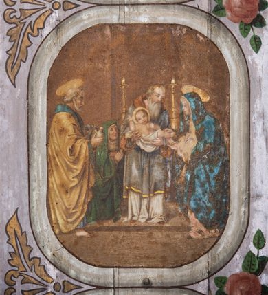 Zdjęcie nr 8: Dekoracją malarską pokryto fasety, stropy w nawie i prezbiterium, a także ich ściany oraz przestrzeń przedsionka pod wieżą. Ściany prezbiterium, nawy i przedsionka artykułowano za pomocą malowanych pilastrów o korynckich głowicach ustawionych na wysokich postumentach, podtrzymujących belkowanie. Pomiędzy pilastrami wprowadzono malowane czworoboczne płyciny o wklęsłych narożach z polem pokrytym marmoryzacją. Wąską fasetę podstropową ozdobiono fryzem z rytmicznie powtarzającym się motywem liścia palmetowego. Strop w prezbiterium i nawie uzyskał architektoniczne obramienie sceny centralnej ujętej w prostokątne pole o zaokrąglonych narożach, utworzone z iluzjonistycznie malowanych listew i zawieszonych pomiędzy nimi girland liściastych. W prezbiterium wyobrażono Trójcę Świętą, a w nawie Koronację Marii obwiedzioną tajemnicami różańcowymi w medalionach. Trójcę Świętą ukazano na obłokach na niebieskim tle. Majestatyczny Bóg Ojciec został ukazany w trzech czwartych w lewo jako siwobrody starzec o bujnych siwych włosach. W prawej ręce trzyma złote berło, lewą zaś odsuwa do siebie. Bóg Ojciec stopy wspiera o niebieski glob wyłaniający się z obłoków poniżej. Jego twarz charakteryzuje jasna karnacja, szeroko otwarte oczy, wydatny nos i usta. Głowę otacza długa, siwa broda i podobne włosy. Ubrany jest w mocno drapowaną białą tunikę i narzucony na nią rozwiany, złocisty płaszcz obszyty dekoracyjną bortą, spięty klamrą na lewym ramieniu. Obok Boga Ojca z lewej strony siedzi Chrystus, który obie, skrzyżowane nogi wspiera na globie. Zbawiciel prawą ręką podtrzymuje oparty o ramię drewniany krzyż, lewą zaś ma odsuniętą od siebie z gestem wskazującym na Ojca. Jezus został przedstawiony w trzech czwartych w prawo. Jest to dojrzały mężczyzna o pociągłej twarzy okolonej brązowymi, długimi włosami spływającymi na ramiona oraz brodą. Ma jasną karnację, prosty nos i wydatne usta. Nagi tors okrywa bladoszkarłatny płaszcz odsłaniający obie stopy Na dłoniach i stopach widoczne są rany po gwoździach. Głowę Jezusa okala świetlisty nimb. Powyżej obu postaci na tle rozjaśnionego nieba unosi się gołębica Ducha Świętego w promienistym otoku. Koronację Marii otoczoną przez owalne  medaliony ze scenami różańcowymi namalowano w polu dekoracyjnego, wydłużonego czworobocznego panneau o narożach utworzonych z roślinnego ornamentu powtórzonego symetrycznie na dłuższych bokach w środku. W centrum czworoboku o zaokrąglonych narożach obwiedzionych motywem różańca przedstawiono klęczącą na obłokach Marię przed koronującą ją Trójcą Świętą. Madonna jako młoda dziewczyna ujęta została w profilu w lewo. Lewą rękę ma przyłożoną do piersi, prawą zaś podaje synowi. Jej owalna twarz ma jasną karnację o wydatnym nosie i ustach. Głowę otaczają brązowe włosy spływające na plecy. Maria ubrana jest w lamowany złotą taśmą niebieski połaszcz oraz fragmentarycznie widoczną czerwoną suknię. Przed nią siedzi Chrystus, a za nim Bóg Ojciec. Pomiędzy nimi widać w jasnym otoku gołębicę Ducha Świętego. Jezus został ujęty w profilu w prawo. Prawą ręką unosi wraz Ojcem złotą koronę nad głową matki. Lewą zaś wspartą na kolanie trzyma jej prawą dłoń. Chrystus ma pociągłą twarz o jasnej karnacji i rumianych policzkach, wydatny nos i usta. Jego głowę otaczają długie brązowe włosy spływające na plecy oraz krótki zarost. Na głowie ma złoty diadem. Ubrany jest w niebieską tunikę i czerwony, mocno wywinięty płaszcz o jasnobeżowej podszewce. Spod tuniki widać fragmenty bosych stóp wspartych na obłokach. Obok Zbawiciela fragmentarycznie widać postać Boga Ojca ujętego frontalnie. Jest to starszy mężczyzna o siwym, obfitym zaroście i włosach. Ma wydatny nos i usta, a na głowie złoty diadem w formie mitry. Postacie ujmuje złocista, migdałowa mandorla utworzona z jasnego obramienia, na którym ukazano uskrzydlone główki serafinów. Dolną część mandorli spowijają obłoki. Całość ukazano na niebieskim tle usianym gwiazdami. Wokół centralnego przedstawienia rozmieszczono czternaście owalnych medalionów różańcowych. Ich narracja rozpoczyna się na osi ponad sceną z koronacją Marii. Idąc w lewo namalowano: Zwiastowanie Marii, Nawiedzenie św. Elżbiety, Boże Narodzenie, Ofiarowanie w świątyni, Znalezienie w świątyni, Modlitwa w Ogrójcu, Biczowanie, Cierniem ukoronowanie, Niesienie krzyża, Ukrzyżowanie, Zmartwychwstanie, Wniebowstąpienie, Zesłanie Ducha Świętego i Wniebowzięcie Marii. Pomiędzy medalionami namalowano czerwone róże.    