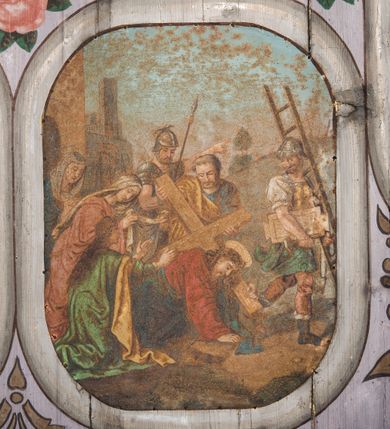 Zdjęcie nr 13: Dekoracją malarską pokryto fasety, stropy w nawie i prezbiterium, a także ich ściany oraz przestrzeń przedsionka pod wieżą. Ściany prezbiterium, nawy i przedsionka artykułowano za pomocą malowanych pilastrów o korynckich głowicach ustawionych na wysokich postumentach, podtrzymujących belkowanie. Pomiędzy pilastrami wprowadzono malowane czworoboczne płyciny o wklęsłych narożach z polem pokrytym marmoryzacją. Wąską fasetę podstropową ozdobiono fryzem z rytmicznie powtarzającym się motywem liścia palmetowego. Strop w prezbiterium i nawie uzyskał architektoniczne obramienie sceny centralnej ujętej w prostokątne pole o zaokrąglonych narożach, utworzone z iluzjonistycznie malowanych listew i zawieszonych pomiędzy nimi girland liściastych. W prezbiterium wyobrażono Trójcę Świętą, a w nawie Koronację Marii obwiedzioną tajemnicami różańcowymi w medalionach. Trójcę Świętą ukazano na obłokach na niebieskim tle. Majestatyczny Bóg Ojciec został ukazany w trzech czwartych w lewo jako siwobrody starzec o bujnych siwych włosach. W prawej ręce trzyma złote berło, lewą zaś odsuwa do siebie. Bóg Ojciec stopy wspiera o niebieski glob wyłaniający się z obłoków poniżej. Jego twarz charakteryzuje jasna karnacja, szeroko otwarte oczy, wydatny nos i usta. Głowę otacza długa, siwa broda i podobne włosy. Ubrany jest w mocno drapowaną białą tunikę i narzucony na nią rozwiany, złocisty płaszcz obszyty dekoracyjną bortą, spięty klamrą na lewym ramieniu. Obok Boga Ojca z lewej strony siedzi Chrystus, który obie, skrzyżowane nogi wspiera na globie. Zbawiciel prawą ręką podtrzymuje oparty o ramię drewniany krzyż, lewą zaś ma odsuniętą od siebie z gestem wskazującym na Ojca. Jezus został przedstawiony w trzech czwartych w prawo. Jest to dojrzały mężczyzna o pociągłej twarzy okolonej brązowymi, długimi włosami spływającymi na ramiona oraz brodą. Ma jasną karnację, prosty nos i wydatne usta. Nagi tors okrywa bladoszkarłatny płaszcz odsłaniający obie stopy Na dłoniach i stopach widoczne są rany po gwoździach. Głowę Jezusa okala świetlisty nimb. Powyżej obu postaci na tle rozjaśnionego nieba unosi się gołębica Ducha Świętego w promienistym otoku. Koronację Marii otoczoną przez owalne  medaliony ze scenami różańcowymi namalowano w polu dekoracyjnego, wydłużonego czworobocznego panneau o narożach utworzonych z roślinnego ornamentu powtórzonego symetrycznie na dłuższych bokach w środku. W centrum czworoboku o zaokrąglonych narożach obwiedzionych motywem różańca przedstawiono klęczącą na obłokach Marię przed koronującą ją Trójcą Świętą. Madonna jako młoda dziewczyna ujęta została w profilu w lewo. Lewą rękę ma przyłożoną do piersi, prawą zaś podaje synowi. Jej owalna twarz ma jasną karnację o wydatnym nosie i ustach. Głowę otaczają brązowe włosy spływające na plecy. Maria ubrana jest w lamowany złotą taśmą niebieski połaszcz oraz fragmentarycznie widoczną czerwoną suknię. Przed nią siedzi Chrystus, a za nim Bóg Ojciec. Pomiędzy nimi widać w jasnym otoku gołębicę Ducha Świętego. Jezus został ujęty w profilu w prawo. Prawą ręką unosi wraz Ojcem złotą koronę nad głową matki. Lewą zaś wspartą na kolanie trzyma jej prawą dłoń. Chrystus ma pociągłą twarz o jasnej karnacji i rumianych policzkach, wydatny nos i usta. Jego głowę otaczają długie brązowe włosy spływające na plecy oraz krótki zarost. Na głowie ma złoty diadem. Ubrany jest w niebieską tunikę i czerwony, mocno wywinięty płaszcz o jasnobeżowej podszewce. Spod tuniki widać fragmenty bosych stóp wspartych na obłokach. Obok Zbawiciela fragmentarycznie widać postać Boga Ojca ujętego frontalnie. Jest to starszy mężczyzna o siwym, obfitym zaroście i włosach. Ma wydatny nos i usta, a na głowie złoty diadem w formie mitry. Postacie ujmuje złocista, migdałowa mandorla utworzona z jasnego obramienia, na którym ukazano uskrzydlone główki serafinów. Dolną część mandorli spowijają obłoki. Całość ukazano na niebieskim tle usianym gwiazdami. Wokół centralnego przedstawienia rozmieszczono czternaście owalnych medalionów różańcowych. Ich narracja rozpoczyna się na osi ponad sceną z koronacją Marii. Idąc w lewo namalowano: Zwiastowanie Marii, Nawiedzenie św. Elżbiety, Boże Narodzenie, Ofiarowanie w świątyni, Znalezienie w świątyni, Modlitwa w Ogrójcu, Biczowanie, Cierniem ukoronowanie, Niesienie krzyża, Ukrzyżowanie, Zmartwychwstanie, Wniebowstąpienie, Zesłanie Ducha Świętego i Wniebowzięcie Marii. Pomiędzy medalionami namalowano czerwone róże.    