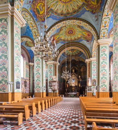 Zdjęcie nr 13: Orientowany kościół pw. Wszystkich Świętych w Wieprzu został wzniesiony w układzie trójnawowej hali z prostokątnym prezbiterium zamkniętym płaską apsydą na przedłużeniu nawy głównej, flankowanego od południa kaplicą, a od północy piętrową zakrystią. Od zachodu do trójprzęsłowego korpusu nawowego dostawiono nieznacznie wysuniętą do przodu czworoboczną wieżę, flankowaną po bokach dwoma aneksami tej samej wysokości, co nawa i aneksy przy prezbiterium. Całość nakryto miedzianym dachem siodłowym. Przy końcu nawy od wschodu na dachu nadwieszono sygnaturkę w formie latarni zwieńczonej ostrosłupowym hełmem. Elewacje zewnętrzne przeprute półokrągłymi oknami artykułowano za pomocą pilastrów o prostych głowicach wspartych na wysoki cokołach połączonych ze sobą gzymsem, podtrzymujących fazowane belkowanie przechodzące w profilowany gzyms koronujący. Elewacje wieży podzielona na dwie strefy rozdzielone belkowaniem wyłamanym w partii masywu wieżowego. W dolnej strefie w przyziemiu urządzono kruchtę, do której wejście na osi flankowane jest masywnym portalem utworzonym z dwóch czworobocznych podpór wspierających trójkątny przyczółek, ponad którym przepruto półokrągłe okno. Ponad gzymsem, w górnej strefie, zastosowano podział ramowy, ujmujący okulus, który pełni partię cokołową wspierającą flankujące górną część wieży pary pilastrów na każdej z czterech elewacji. Pilastry ustawione na postumentach o gładkich trzonach i kompozytowych głowicach wspierają fazowane belkowanie przechodzące w gzyms koronujący. Pomiędzy pilastrami przepruto półokrągłe okna z umieszczonymi nad nimi trójkątnymi przyczółkami. Gzyms został wyłamany na każdej z osi środkowej, tworząc miejsce dla tarcz zegarowych. Wieżę zwieńczono baniastym hełmem z czworoboczną latarnią nakrytą cebulastym zwieńczeniem z krzyżem. Nawa główna otwiera się do naw bocznych z każdej strony otwiera się do naw bocznych z każdej strony trzema opilastrowanymi arkadami filarowymi. Wnętrze nakryto sklepieniem krzyżowym. Chór muzyczny zajmuje szerokość całego korpusu nawowego, wspierając się na pięciu arkadach - trzy w nawie głównej i po jednej w nawach bocznych. Balustrada na chórze artykułowana jest płycinami rozdzielonymi niskim postumentami. W prezbiterium ustawiono ołtarz główny, a na zakończeniu naw ołtarze boczne. Dwa ołtarze boczne znalazły się także w części zachodniej nawy południowej i północnej.