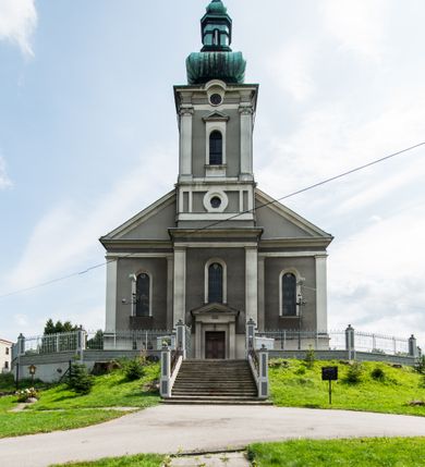 Zdjęcie nr 2: Orientowany kościół pw. Wszystkich Świętych w Wieprzu został wzniesiony w układzie trójnawowej hali z prostokątnym prezbiterium zamkniętym płaską apsydą na przedłużeniu nawy głównej, flankowanego od południa kaplicą, a od północy piętrową zakrystią. Od zachodu do trójprzęsłowego korpusu nawowego dostawiono nieznacznie wysuniętą do przodu czworoboczną wieżę, flankowaną po bokach dwoma aneksami tej samej wysokości, co nawa i aneksy przy prezbiterium. Całość nakryto miedzianym dachem siodłowym. Przy końcu nawy od wschodu na dachu nadwieszono sygnaturkę w formie latarni zwieńczonej ostrosłupowym hełmem. Elewacje zewnętrzne przeprute półokrągłymi oknami artykułowano za pomocą pilastrów o prostych głowicach wspartych na wysoki cokołach połączonych ze sobą gzymsem, podtrzymujących fazowane belkowanie przechodzące w profilowany gzyms koronujący. Elewacje wieży podzielona na dwie strefy rozdzielone belkowaniem wyłamanym w partii masywu wieżowego. W dolnej strefie w przyziemiu urządzono kruchtę, do której wejście na osi flankowane jest masywnym portalem utworzonym z dwóch czworobocznych podpór wspierających trójkątny przyczółek, ponad którym przepruto półokrągłe okno. Ponad gzymsem, w górnej strefie, zastosowano podział ramowy, ujmujący okulus, który pełni partię cokołową wspierającą flankujące górną część wieży pary pilastrów na każdej z czterech elewacji. Pilastry ustawione na postumentach o gładkich trzonach i kompozytowych głowicach wspierają fazowane belkowanie przechodzące w gzyms koronujący. Pomiędzy pilastrami przepruto półokrągłe okna z umieszczonymi nad nimi trójkątnymi przyczółkami. Gzyms został wyłamany na każdej z osi środkowej, tworząc miejsce dla tarcz zegarowych. Wieżę zwieńczono baniastym hełmem z czworoboczną latarnią nakrytą cebulastym zwieńczeniem z krzyżem. Nawa główna otwiera się do naw bocznych z każdej strony otwiera się do naw bocznych z każdej strony trzema opilastrowanymi arkadami filarowymi. Wnętrze nakryto sklepieniem krzyżowym. Chór muzyczny zajmuje szerokość całego korpusu nawowego, wspierając się na pięciu arkadach - trzy w nawie głównej i po jednej w nawach bocznych. Balustrada na chórze artykułowana jest płycinami rozdzielonymi niskim postumentami. W prezbiterium ustawiono ołtarz główny, a na zakończeniu naw ołtarze boczne. Dwa ołtarze boczne znalazły się także w części zachodniej nawy południowej i północnej.