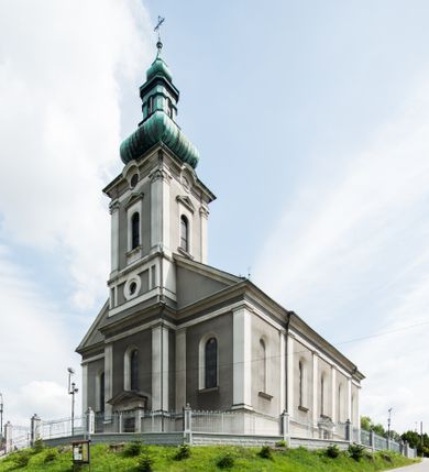 Zdjęcie nr 1: Orientowany kościół pw. Wszystkich Świętych w Wieprzu został wzniesiony w układzie trójnawowej hali z prostokątnym prezbiterium zamkniętym płaską apsydą na przedłużeniu nawy głównej, flankowanego od południa kaplicą, a od północy piętrową zakrystią. Od zachodu do trójprzęsłowego korpusu nawowego dostawiono nieznacznie wysuniętą do przodu czworoboczną wieżę, flankowaną po bokach dwoma aneksami tej samej wysokości, co nawa i aneksy przy prezbiterium. Całość nakryto miedzianym dachem siodłowym. Przy końcu nawy od wschodu na dachu nadwieszono sygnaturkę w formie latarni zwieńczonej ostrosłupowym hełmem. Elewacje zewnętrzne przeprute półokrągłymi oknami artykułowano za pomocą pilastrów o prostych głowicach wspartych na wysoki cokołach połączonych ze sobą gzymsem, podtrzymujących fazowane belkowanie przechodzące w profilowany gzyms koronujący. Elewacje wieży podzielona na dwie strefy rozdzielone belkowaniem wyłamanym w partii masywu wieżowego. W dolnej strefie w przyziemiu urządzono kruchtę, do której wejście na osi flankowane jest masywnym portalem utworzonym z dwóch czworobocznych podpór wspierających trójkątny przyczółek, ponad którym przepruto półokrągłe okno. Ponad gzymsem, w górnej strefie, zastosowano podział ramowy, ujmujący okulus, który pełni partię cokołową wspierającą flankujące górną część wieży pary pilastrów na każdej z czterech elewacji. Pilastry ustawione na postumentach o gładkich trzonach i kompozytowych głowicach wspierają fazowane belkowanie przechodzące w gzyms koronujący. Pomiędzy pilastrami przepruto półokrągłe okna z umieszczonymi nad nimi trójkątnymi przyczółkami. Gzyms został wyłamany na każdej z osi środkowej, tworząc miejsce dla tarcz zegarowych. Wieżę zwieńczono baniastym hełmem z czworoboczną latarnią nakrytą cebulastym zwieńczeniem z krzyżem. Nawa główna otwiera się do naw bocznych z każdej strony otwiera się do naw bocznych z każdej strony trzema opilastrowanymi arkadami filarowymi. Wnętrze nakryto sklepieniem krzyżowym. Chór muzyczny zajmuje szerokość całego korpusu nawowego, wspierając się na pięciu arkadach - trzy w nawie głównej i po jednej w nawach bocznych. Balustrada na chórze artykułowana jest płycinami rozdzielonymi niskim postumentami. W prezbiterium ustawiono ołtarz główny, a na zakończeniu naw ołtarze boczne. Dwa ołtarze boczne znalazły się także w części zachodniej nawy południowej i północnej.