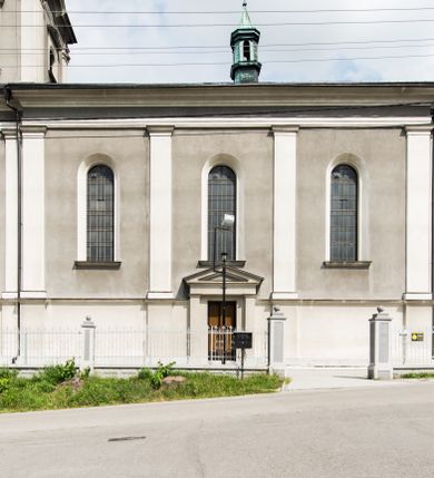 Zdjęcie nr 4: Orientowany kościół pw. Wszystkich Świętych w Wieprzu został wzniesiony w układzie trójnawowej hali z prostokątnym prezbiterium zamkniętym płaską apsydą na przedłużeniu nawy głównej, flankowanego od południa kaplicą, a od północy piętrową zakrystią. Od zachodu do trójprzęsłowego korpusu nawowego dostawiono nieznacznie wysuniętą do przodu czworoboczną wieżę, flankowaną po bokach dwoma aneksami tej samej wysokości, co nawa i aneksy przy prezbiterium. Całość nakryto miedzianym dachem siodłowym. Przy końcu nawy od wschodu na dachu nadwieszono sygnaturkę w formie latarni zwieńczonej ostrosłupowym hełmem. Elewacje zewnętrzne przeprute półokrągłymi oknami artykułowano za pomocą pilastrów o prostych głowicach wspartych na wysoki cokołach połączonych ze sobą gzymsem, podtrzymujących fazowane belkowanie przechodzące w profilowany gzyms koronujący. Elewacje wieży podzielona na dwie strefy rozdzielone belkowaniem wyłamanym w partii masywu wieżowego. W dolnej strefie w przyziemiu urządzono kruchtę, do której wejście na osi flankowane jest masywnym portalem utworzonym z dwóch czworobocznych podpór wspierających trójkątny przyczółek, ponad którym przepruto półokrągłe okno. Ponad gzymsem, w górnej strefie, zastosowano podział ramowy, ujmujący okulus, który pełni partię cokołową wspierającą flankujące górną część wieży pary pilastrów na każdej z czterech elewacji. Pilastry ustawione na postumentach o gładkich trzonach i kompozytowych głowicach wspierają fazowane belkowanie przechodzące w gzyms koronujący. Pomiędzy pilastrami przepruto półokrągłe okna z umieszczonymi nad nimi trójkątnymi przyczółkami. Gzyms został wyłamany na każdej z osi środkowej, tworząc miejsce dla tarcz zegarowych. Wieżę zwieńczono baniastym hełmem z czworoboczną latarnią nakrytą cebulastym zwieńczeniem z krzyżem. Nawa główna otwiera się do naw bocznych z każdej strony otwiera się do naw bocznych z każdej strony trzema opilastrowanymi arkadami filarowymi. Wnętrze nakryto sklepieniem krzyżowym. Chór muzyczny zajmuje szerokość całego korpusu nawowego, wspierając się na pięciu arkadach - trzy w nawie głównej i po jednej w nawach bocznych. Balustrada na chórze artykułowana jest płycinami rozdzielonymi niskim postumentami. W prezbiterium ustawiono ołtarz główny, a na zakończeniu naw ołtarze boczne. Dwa ołtarze boczne znalazły się także w części zachodniej nawy południowej i północnej.