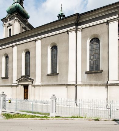 Zdjęcie nr 5: Orientowany kościół pw. Wszystkich Świętych w Wieprzu został wzniesiony w układzie trójnawowej hali z prostokątnym prezbiterium zamkniętym płaską apsydą na przedłużeniu nawy głównej, flankowanego od południa kaplicą, a od północy piętrową zakrystią. Od zachodu do trójprzęsłowego korpusu nawowego dostawiono nieznacznie wysuniętą do przodu czworoboczną wieżę, flankowaną po bokach dwoma aneksami tej samej wysokości, co nawa i aneksy przy prezbiterium. Całość nakryto miedzianym dachem siodłowym. Przy końcu nawy od wschodu na dachu nadwieszono sygnaturkę w formie latarni zwieńczonej ostrosłupowym hełmem. Elewacje zewnętrzne przeprute półokrągłymi oknami artykułowano za pomocą pilastrów o prostych głowicach wspartych na wysoki cokołach połączonych ze sobą gzymsem, podtrzymujących fazowane belkowanie przechodzące w profilowany gzyms koronujący. Elewacje wieży podzielona na dwie strefy rozdzielone belkowaniem wyłamanym w partii masywu wieżowego. W dolnej strefie w przyziemiu urządzono kruchtę, do której wejście na osi flankowane jest masywnym portalem utworzonym z dwóch czworobocznych podpór wspierających trójkątny przyczółek, ponad którym przepruto półokrągłe okno. Ponad gzymsem, w górnej strefie, zastosowano podział ramowy, ujmujący okulus, który pełni partię cokołową wspierającą flankujące górną część wieży pary pilastrów na każdej z czterech elewacji. Pilastry ustawione na postumentach o gładkich trzonach i kompozytowych głowicach wspierają fazowane belkowanie przechodzące w gzyms koronujący. Pomiędzy pilastrami przepruto półokrągłe okna z umieszczonymi nad nimi trójkątnymi przyczółkami. Gzyms został wyłamany na każdej z osi środkowej, tworząc miejsce dla tarcz zegarowych. Wieżę zwieńczono baniastym hełmem z czworoboczną latarnią nakrytą cebulastym zwieńczeniem z krzyżem. Nawa główna otwiera się do naw bocznych z każdej strony otwiera się do naw bocznych z każdej strony trzema opilastrowanymi arkadami filarowymi. Wnętrze nakryto sklepieniem krzyżowym. Chór muzyczny zajmuje szerokość całego korpusu nawowego, wspierając się na pięciu arkadach - trzy w nawie głównej i po jednej w nawach bocznych. Balustrada na chórze artykułowana jest płycinami rozdzielonymi niskim postumentami. W prezbiterium ustawiono ołtarz główny, a na zakończeniu naw ołtarze boczne. Dwa ołtarze boczne znalazły się także w części zachodniej nawy południowej i północnej.